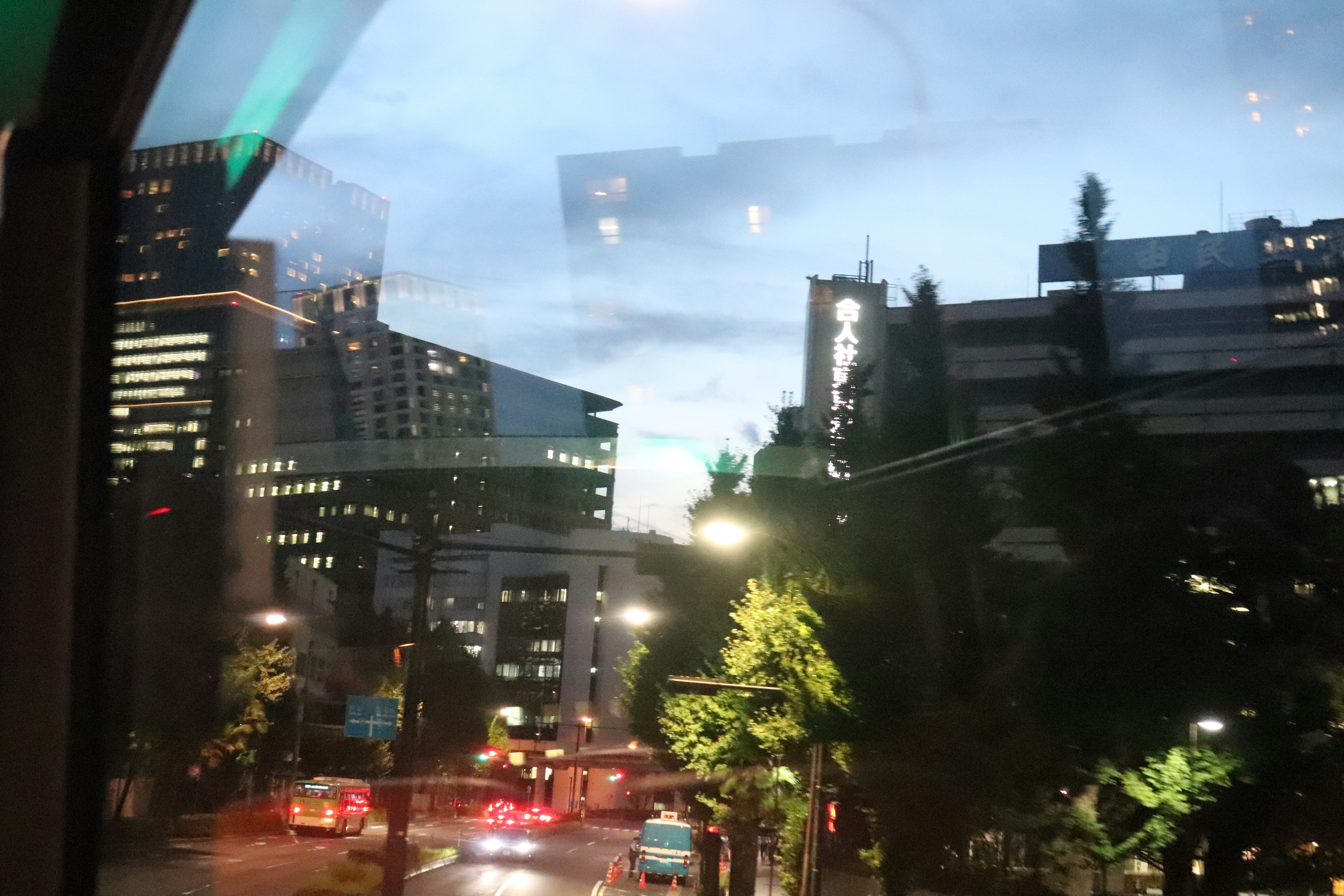 Cityscape during twilight featuring skyscrapers and streetlights