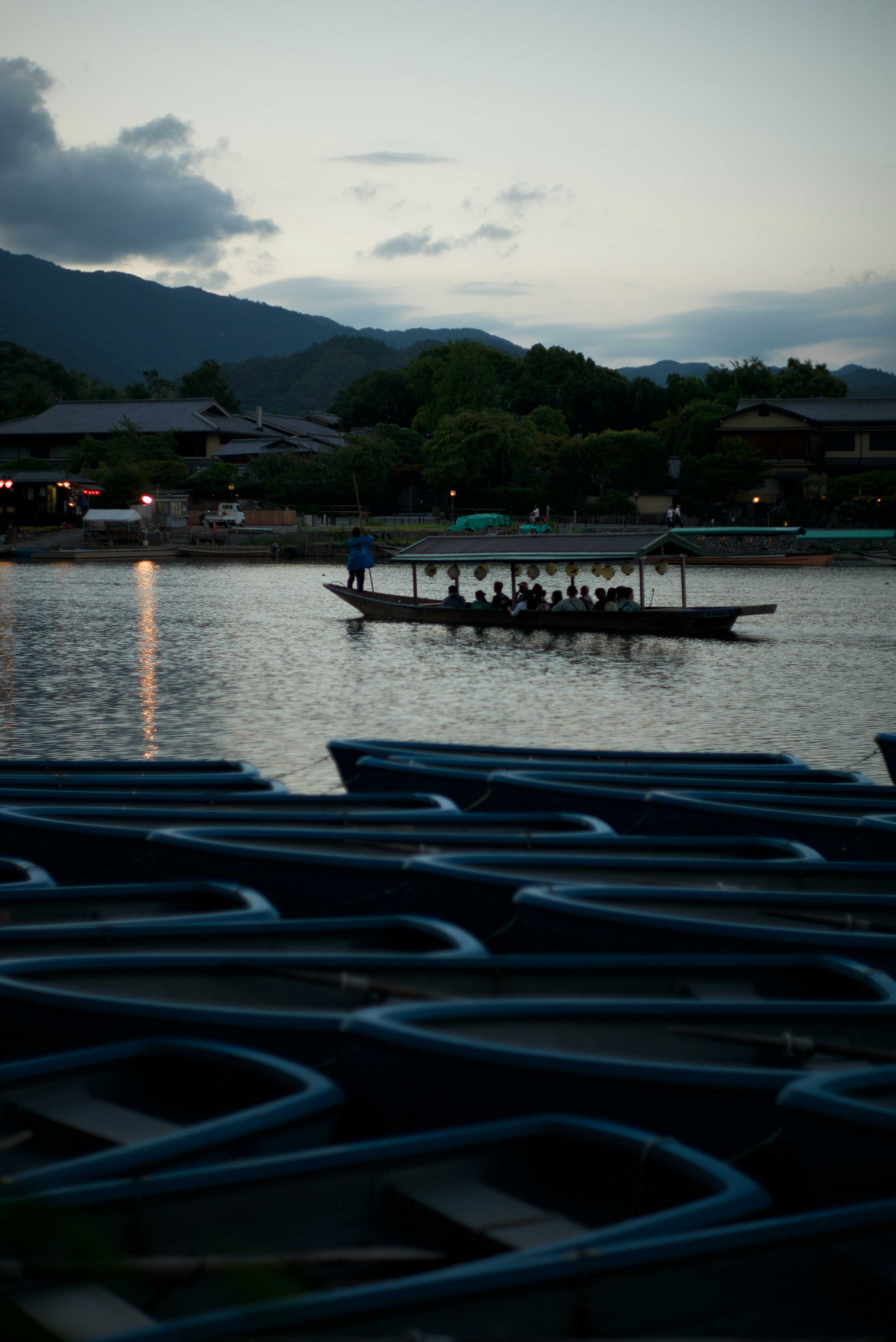 A tranquil dusk scene with a boat on the water surrounded by mountains