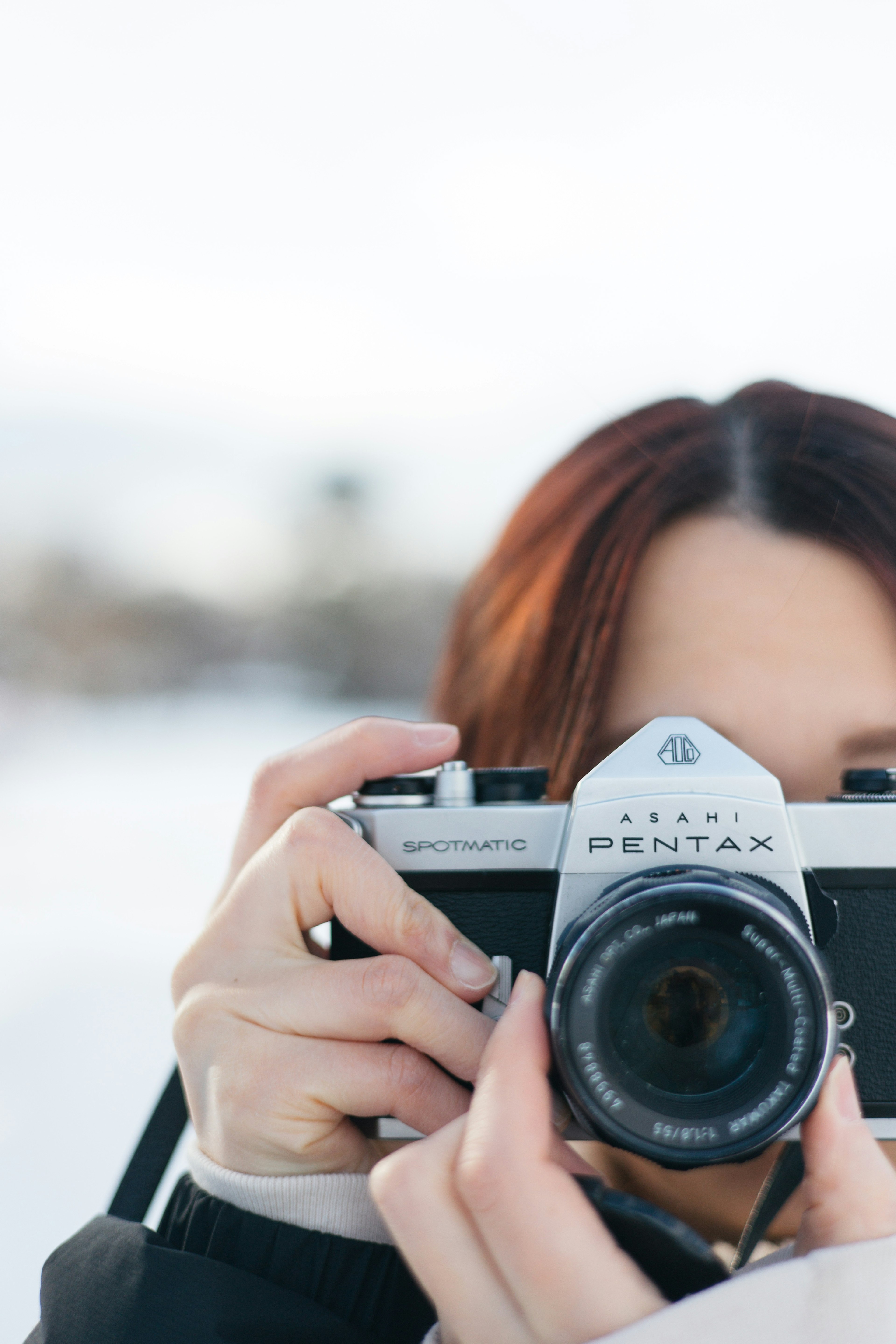 Portrait of a woman holding a camera in the snow