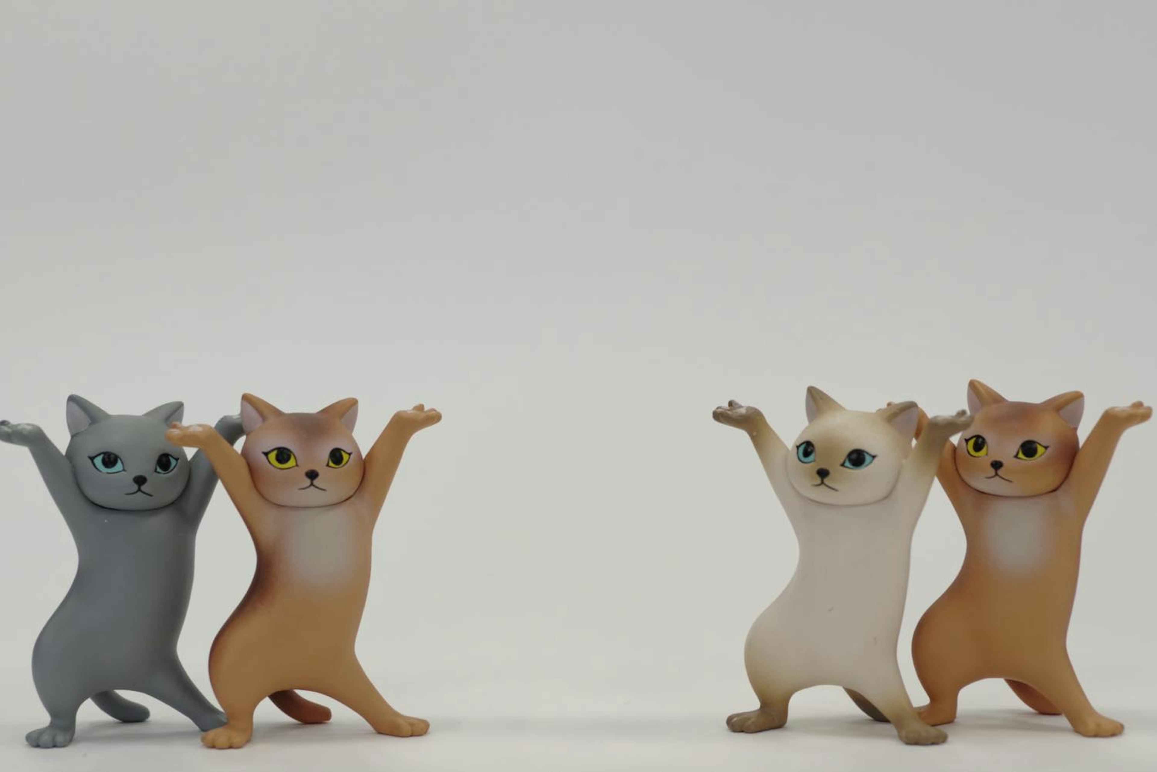 Two cat figurines standing on either side with raised arms