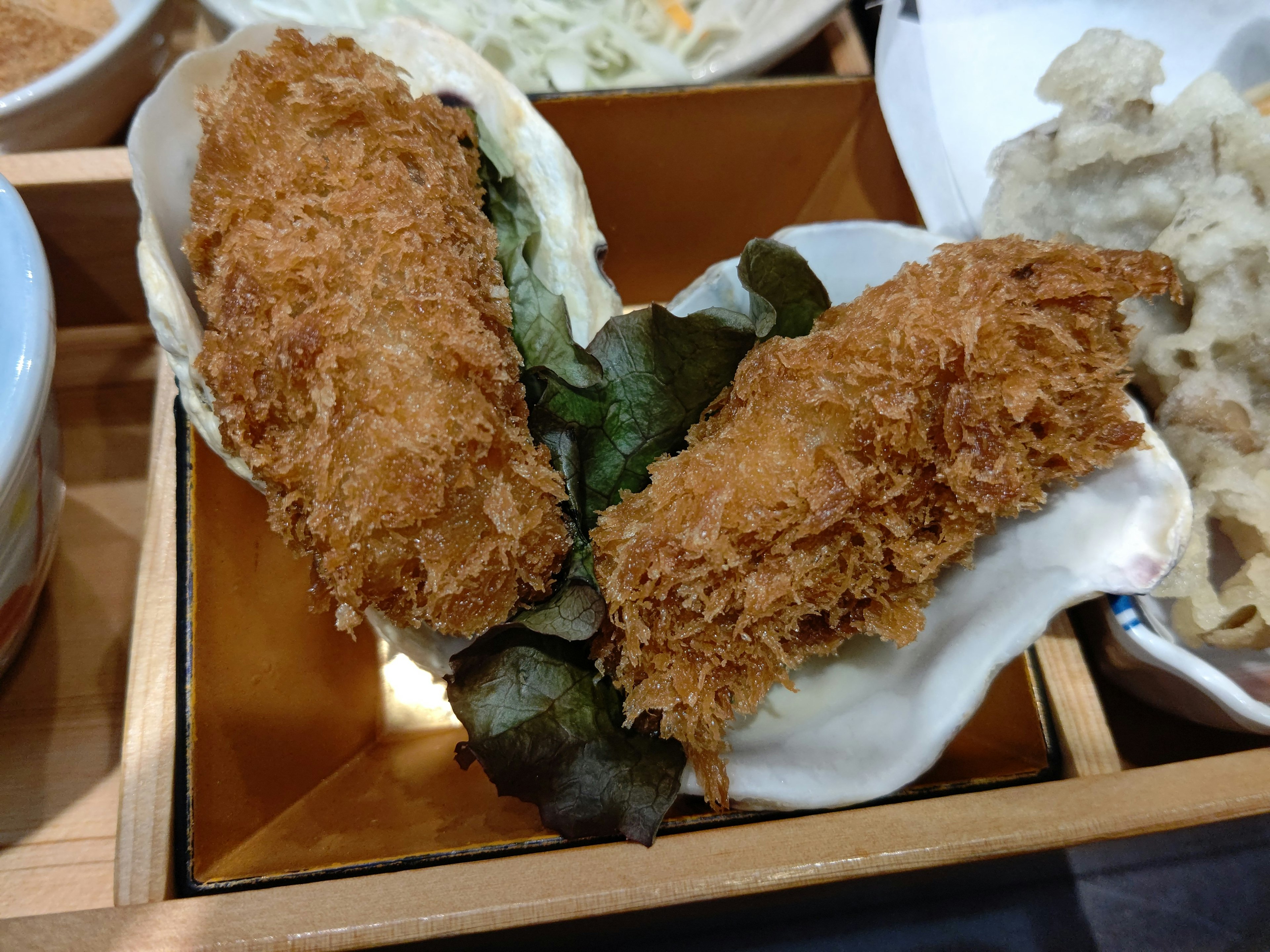 Japanese-style dish featuring two pieces of fried oysters