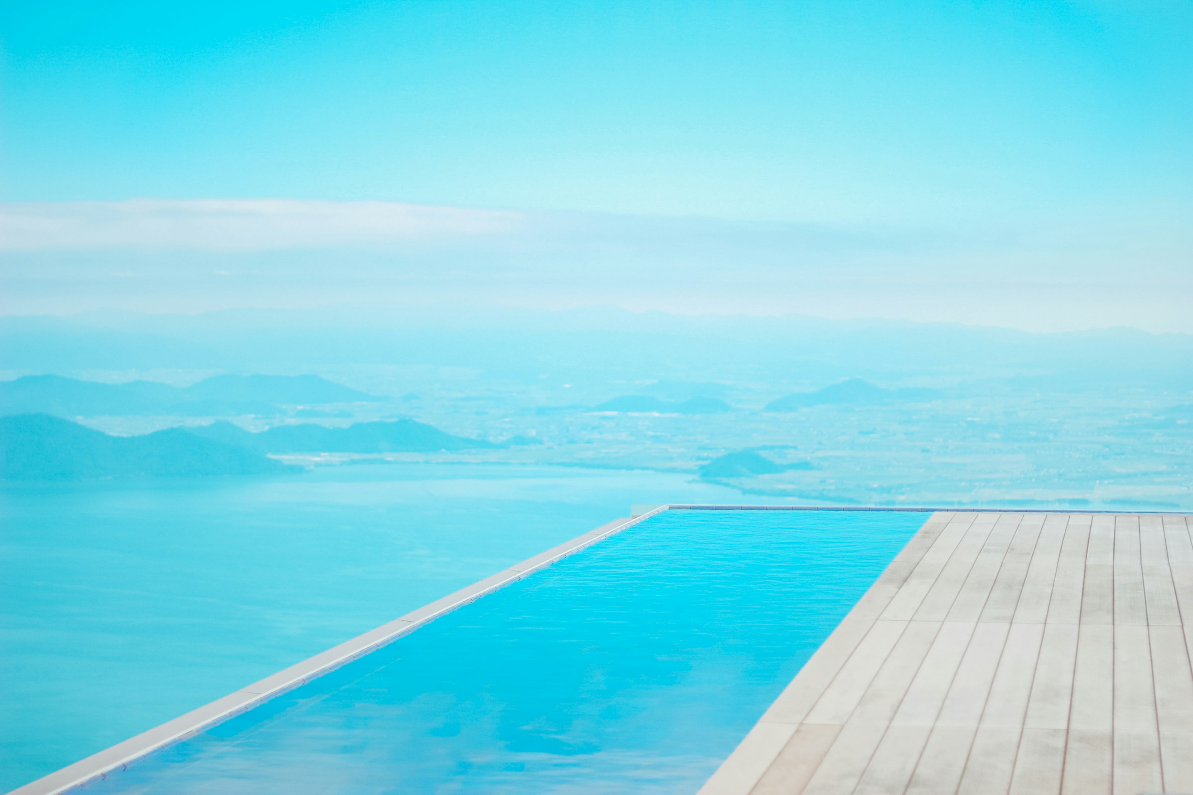 Piscina infinita con vista a un paisaje azul sereno