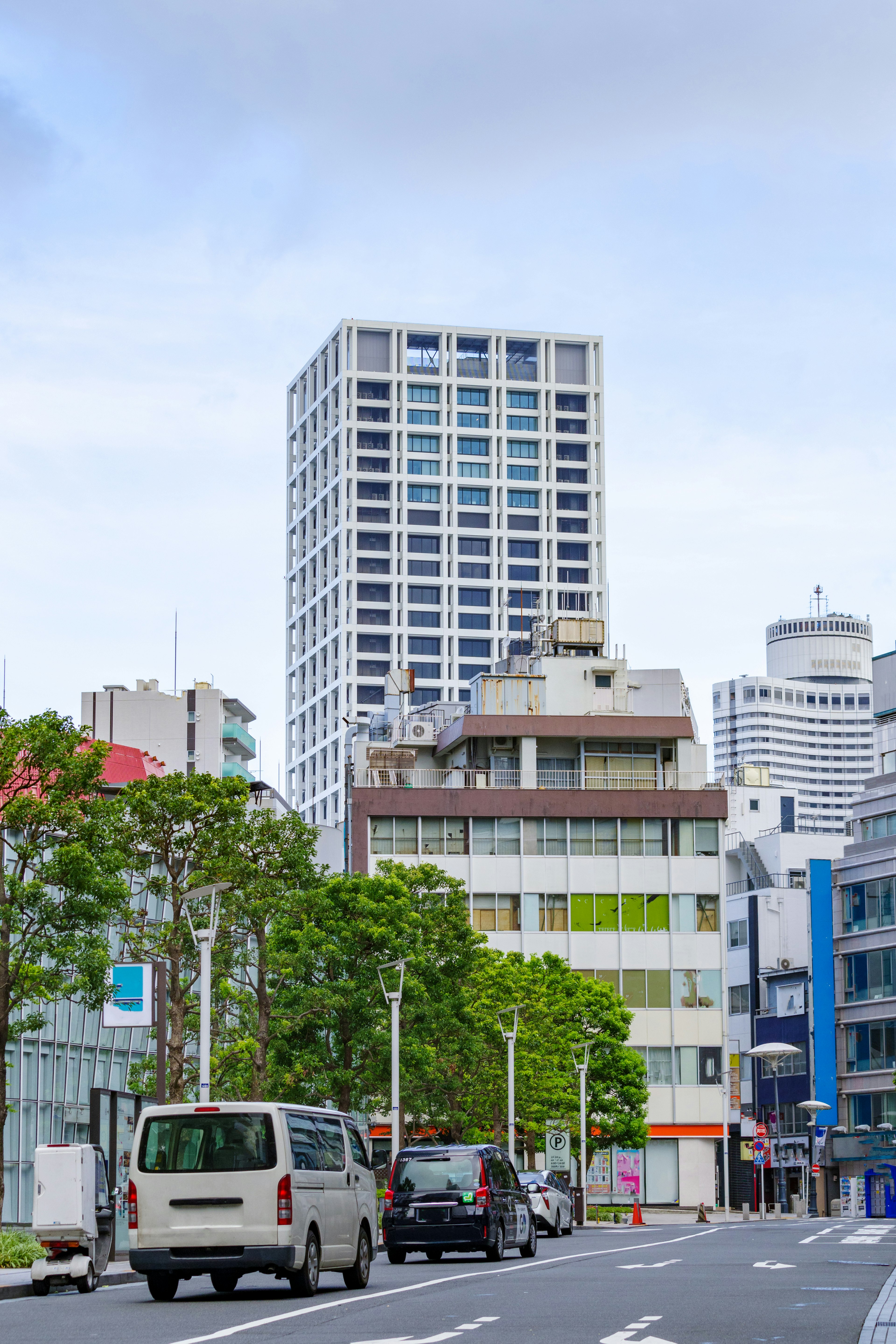 Modern skyscraper and surrounding buildings on an urban street