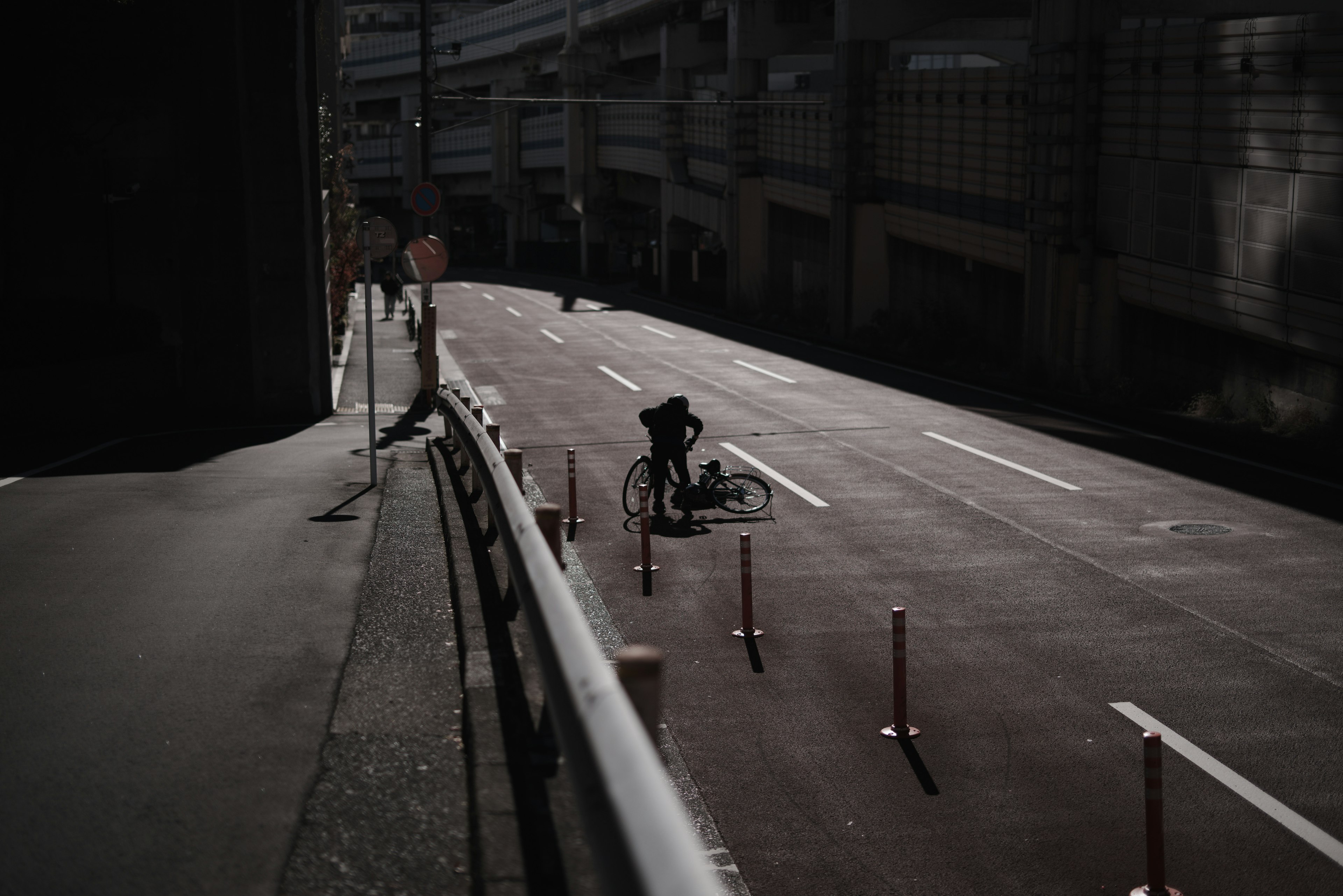 A cyclist on a dark road with traffic cones