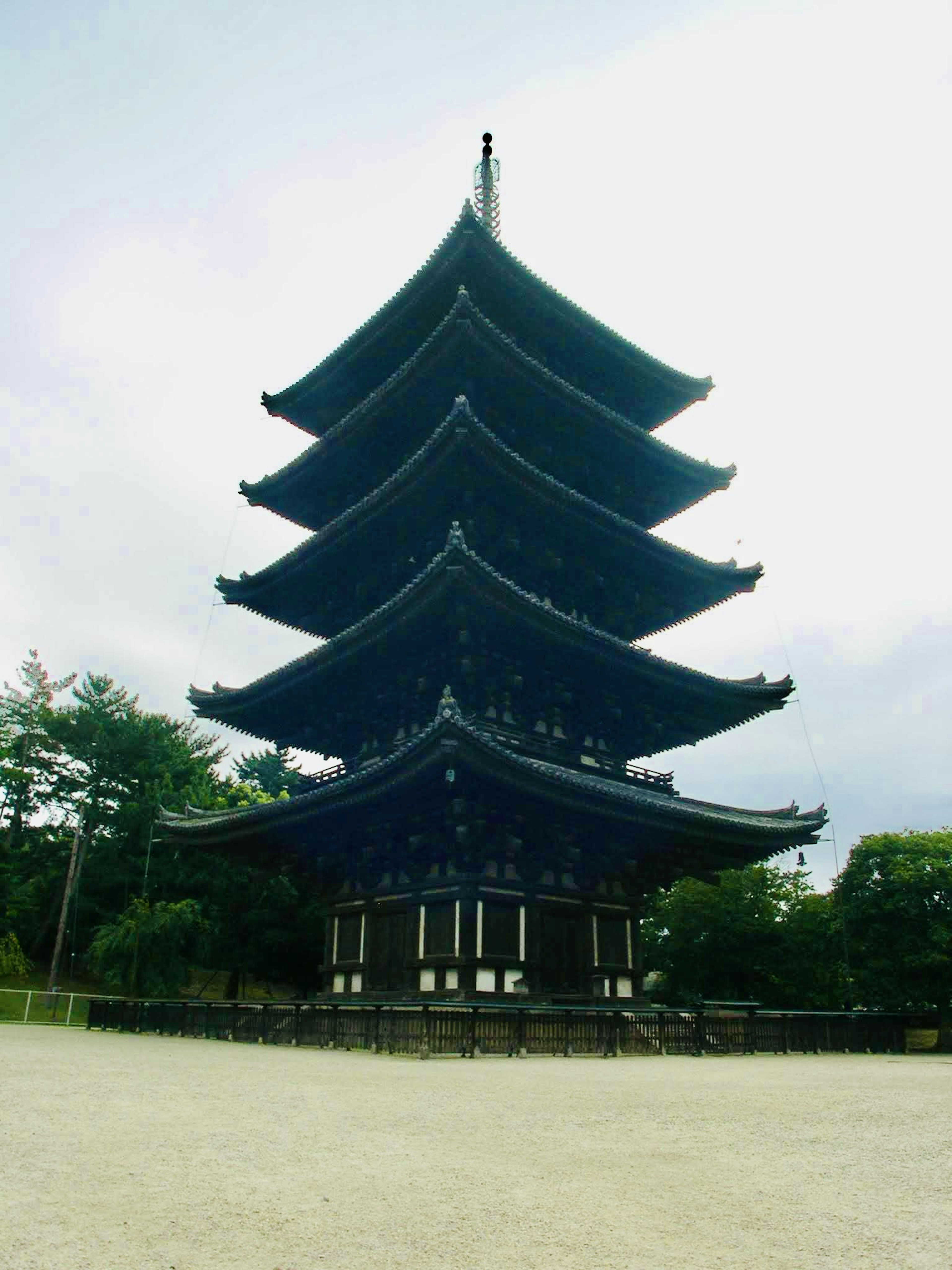 Une pagode bleue à cinq étages se tenant sous un ciel dégagé