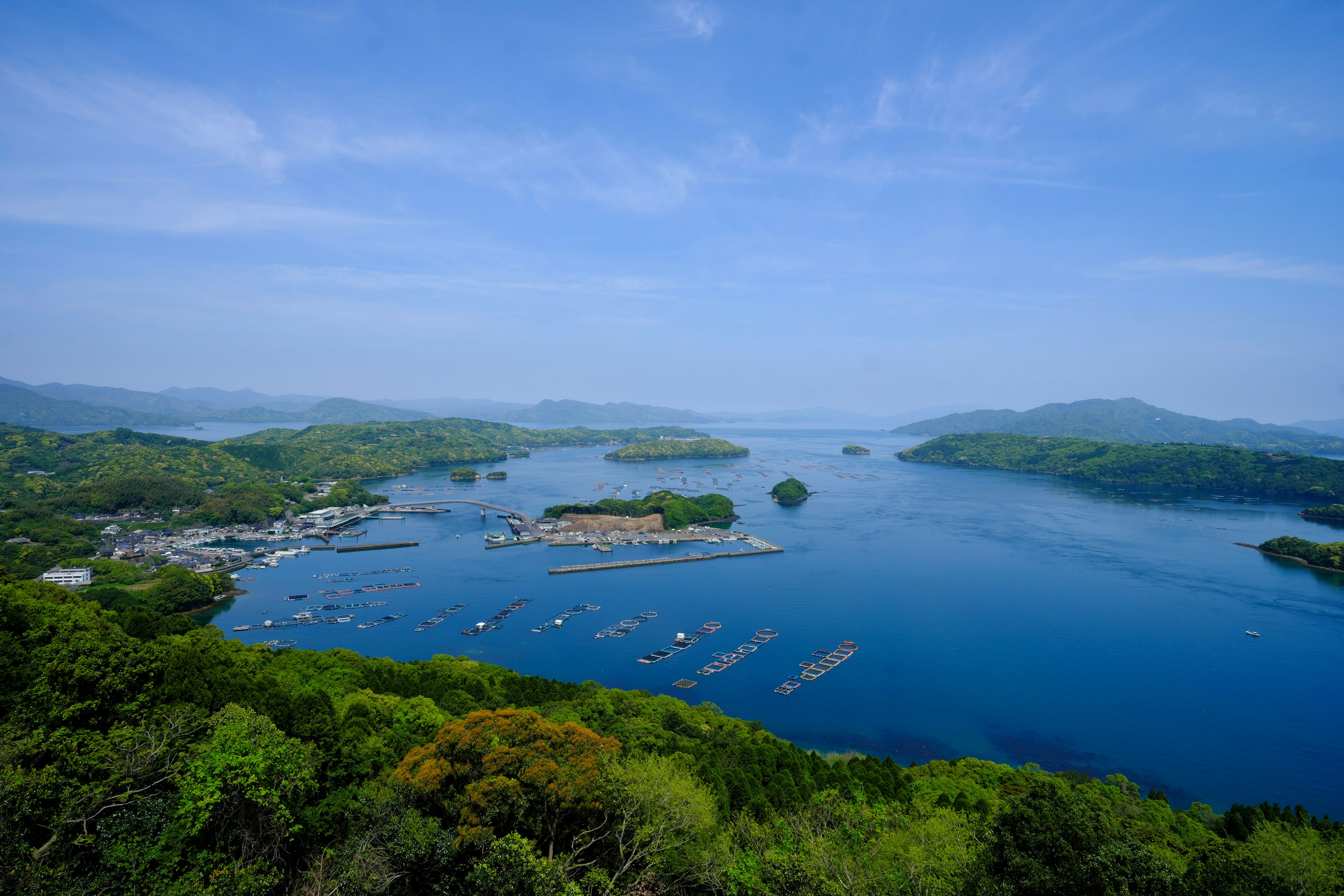 Panoramablick auf das blaue Meer und grüne Inseln mit einem Hafen und Booten