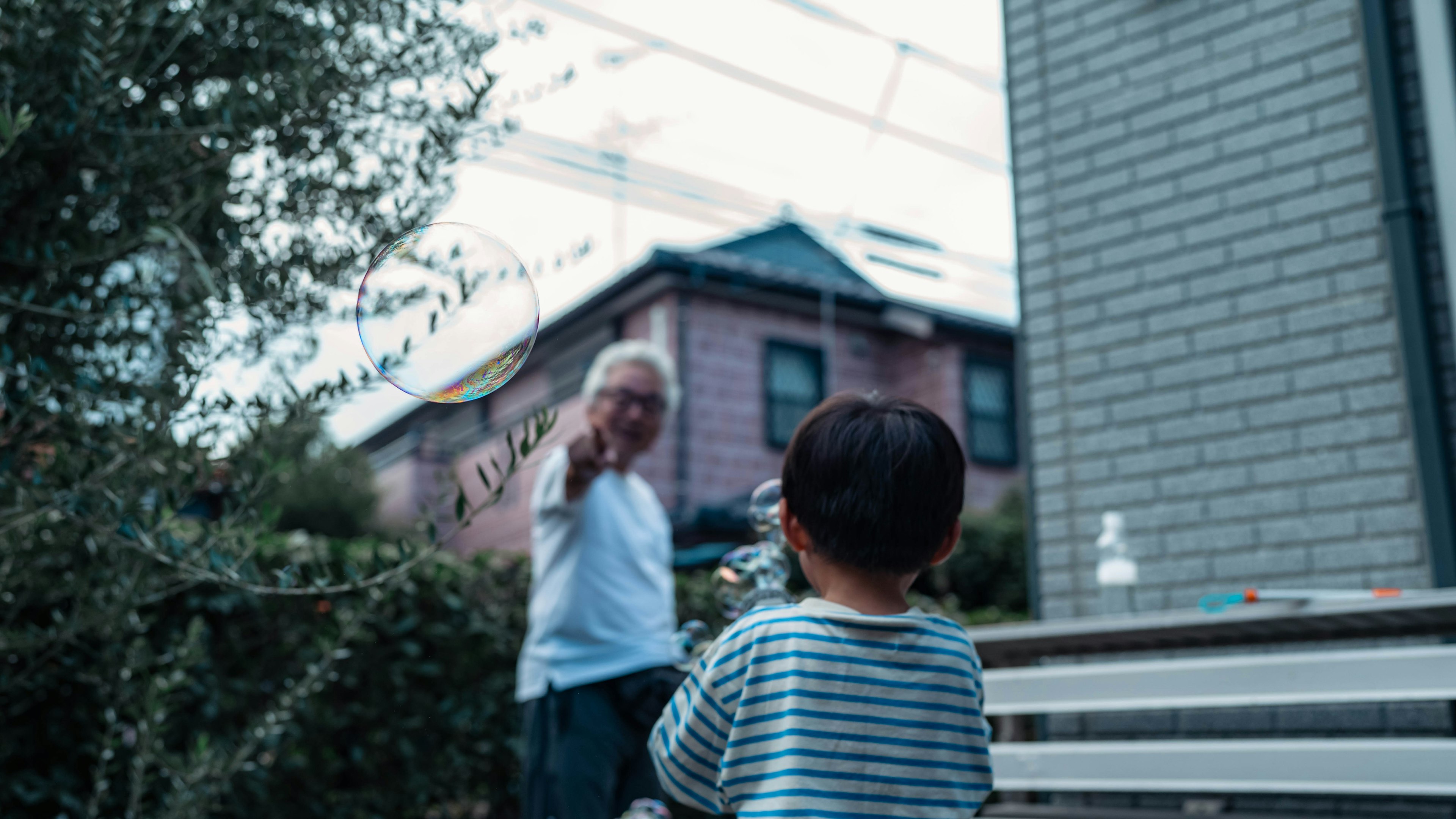 Un homme âgé saluant un enfant dans un jardin