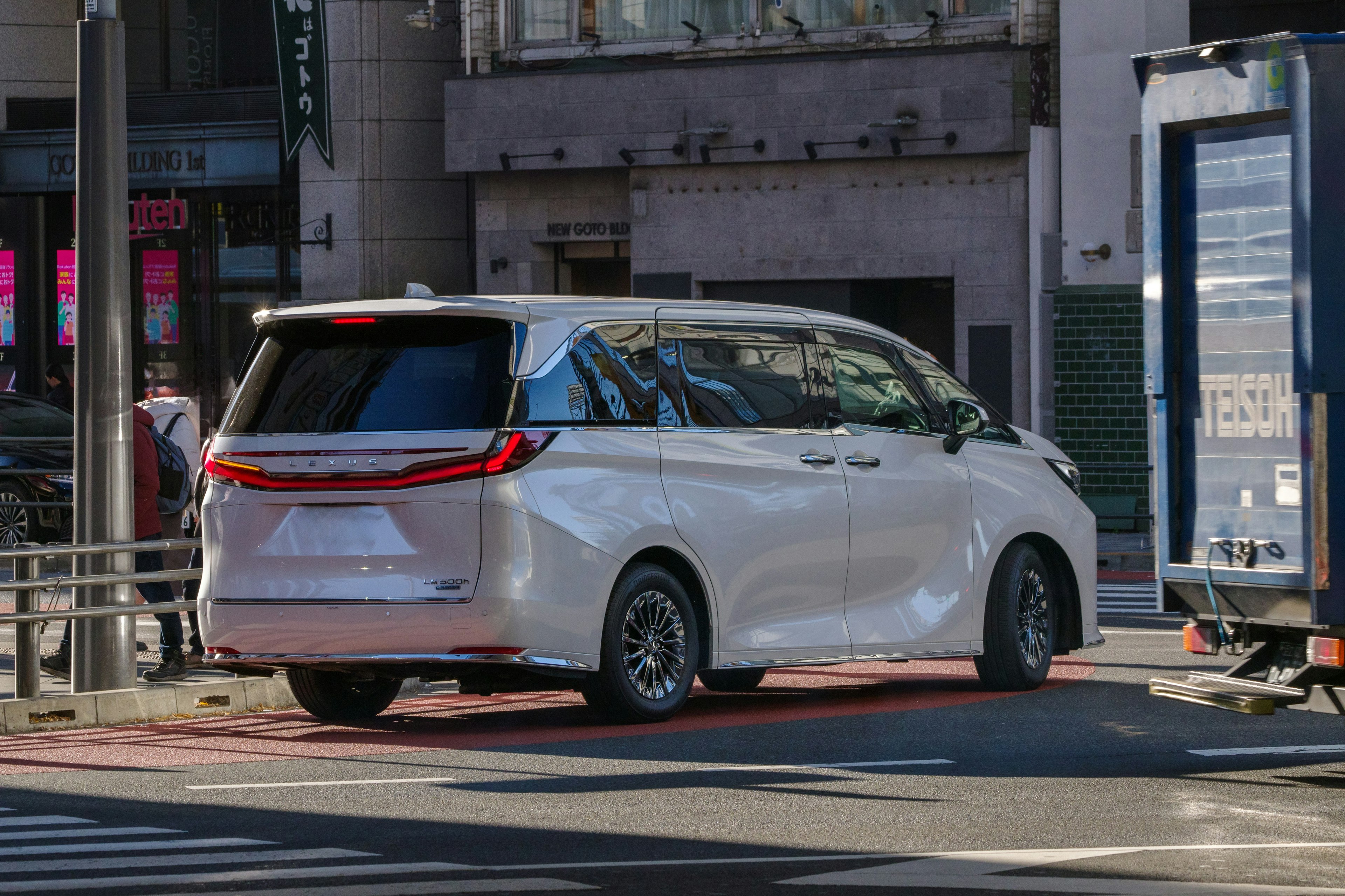 Minivan blanca conduciendo por la ciudad