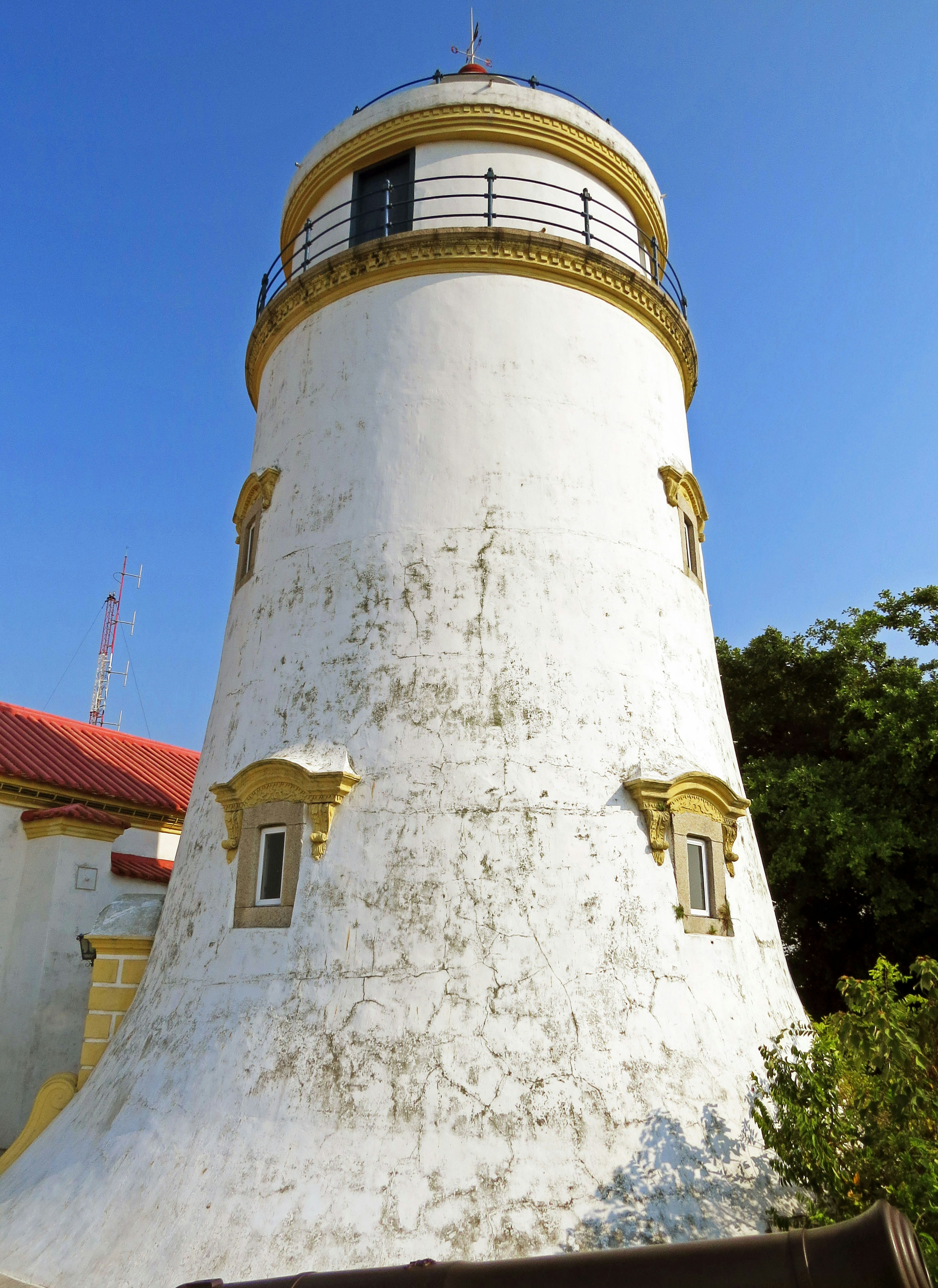 Blick auf einen weißen Leuchtturm unter einem blauen Himmel