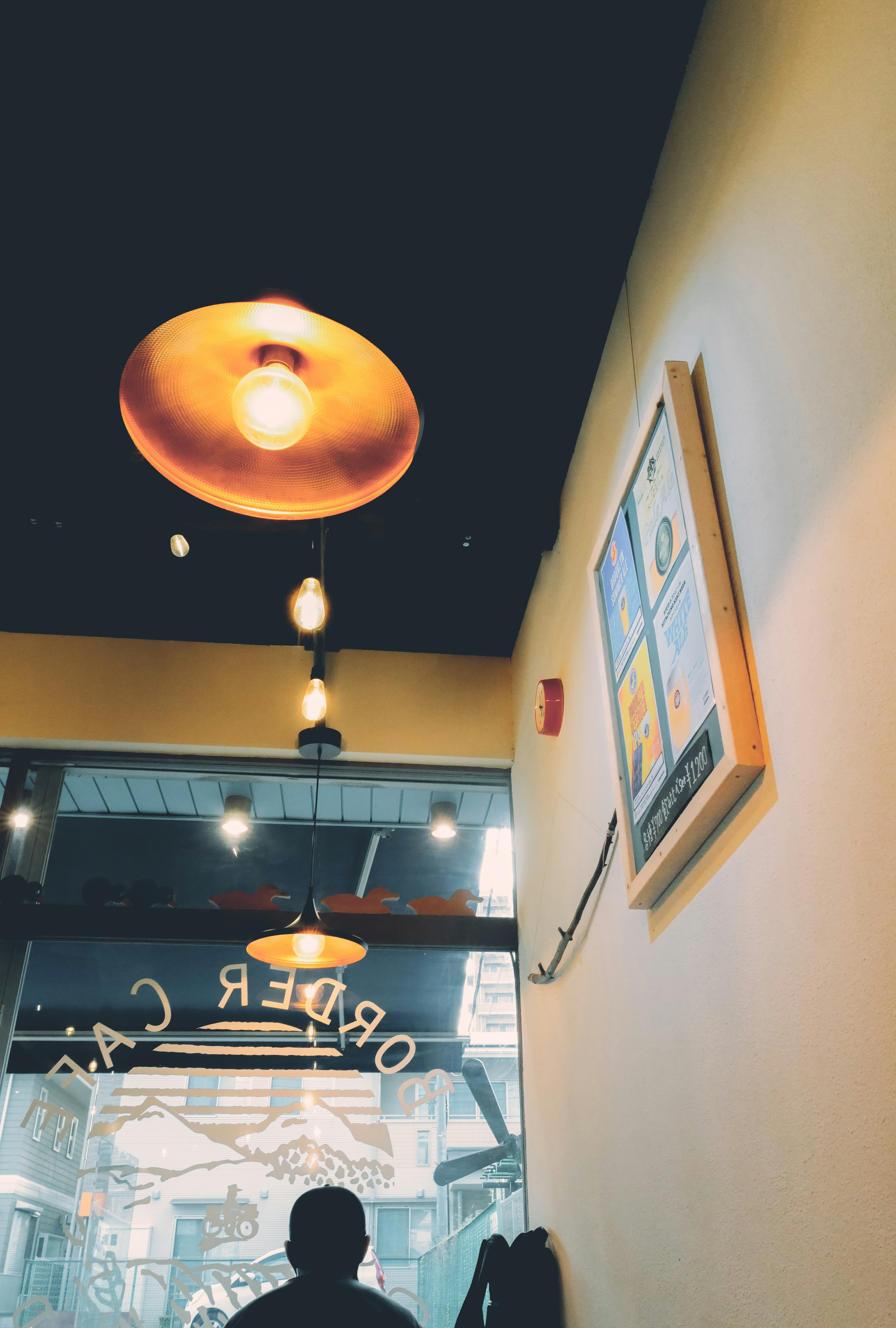 Interior de una cafetería con iluminación única y decoración en la pared