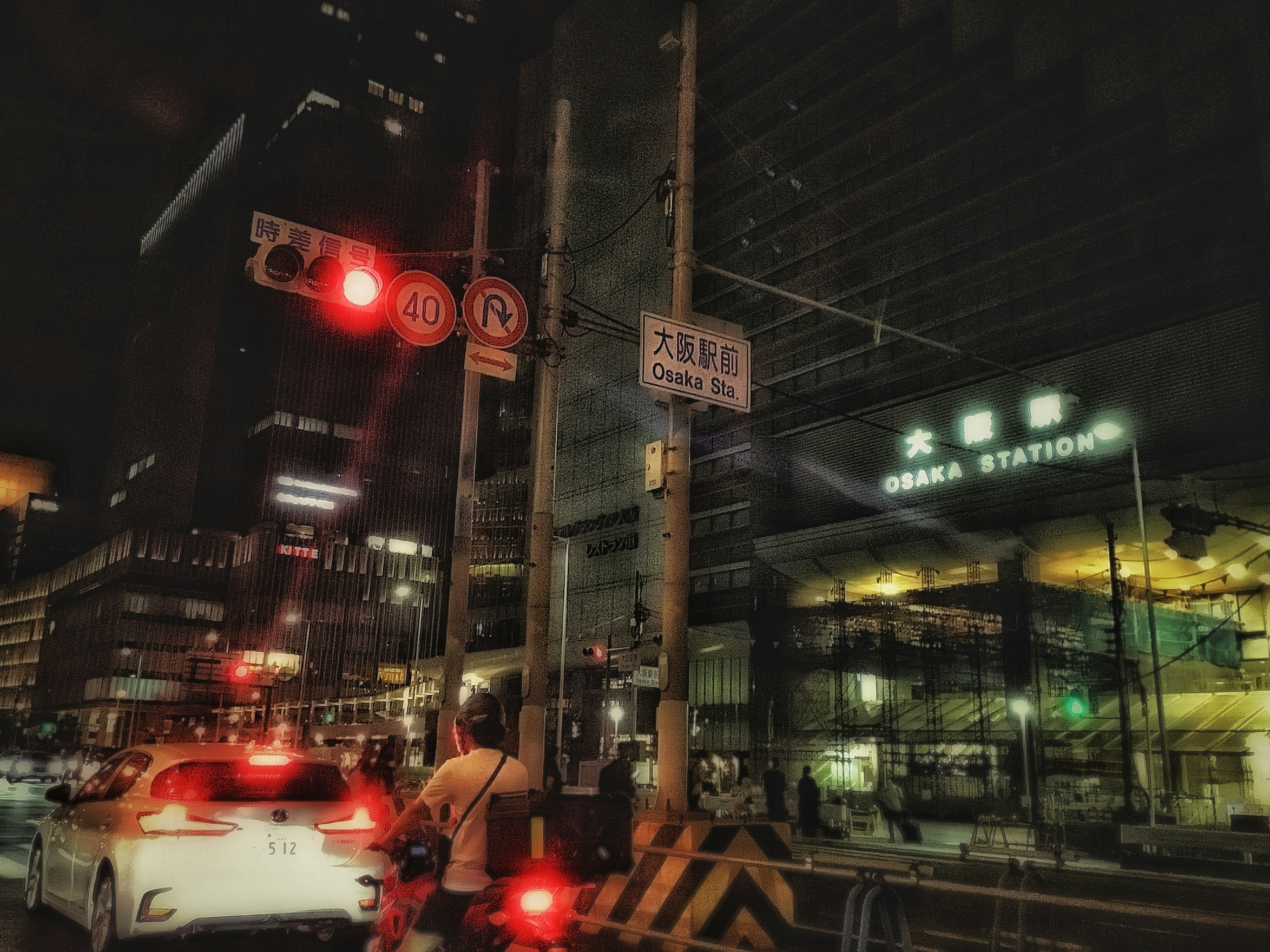 Night scene featuring a red traffic light and a station sign