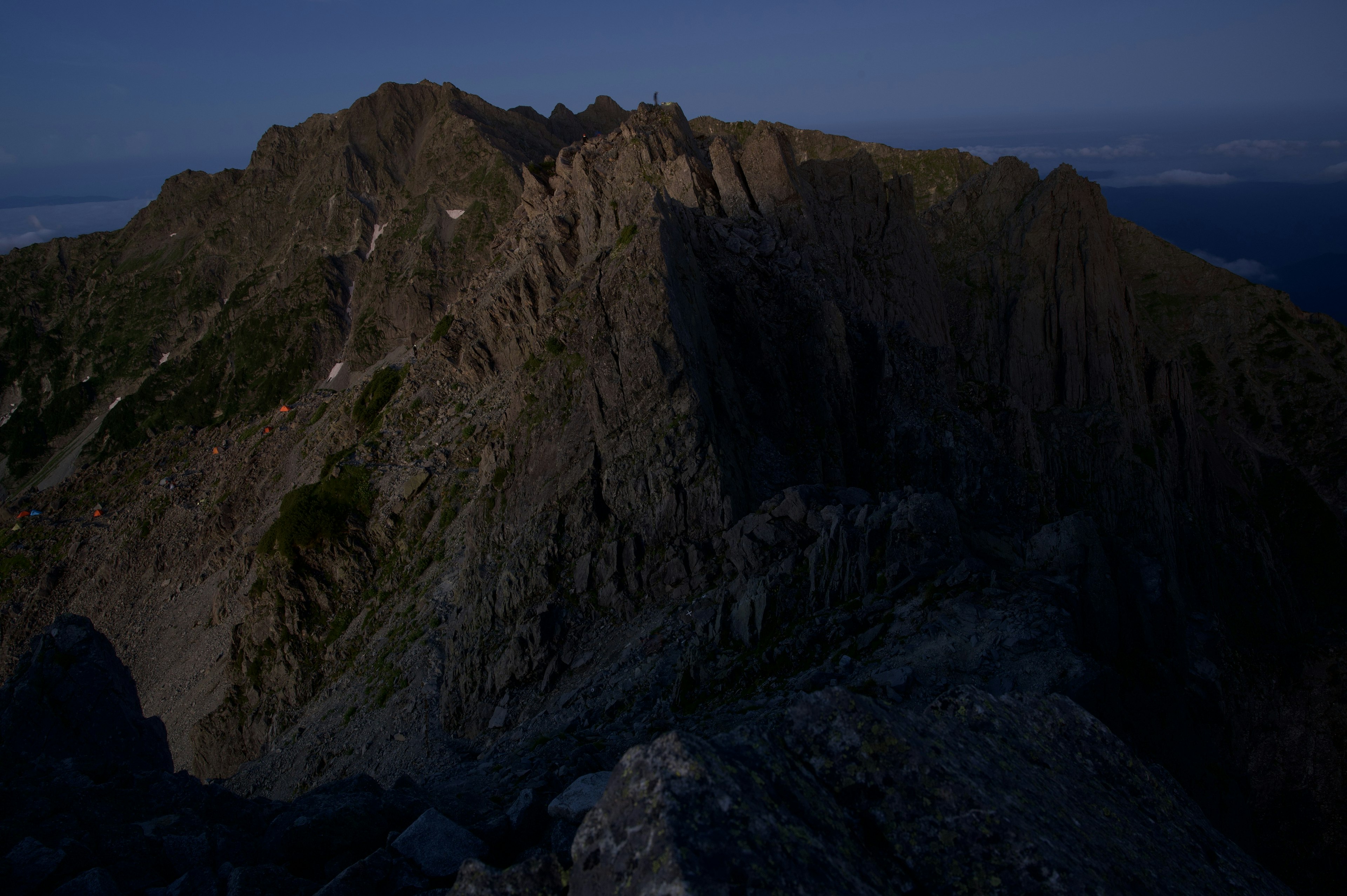 Dark mountain ridge landscape with rocky terrain