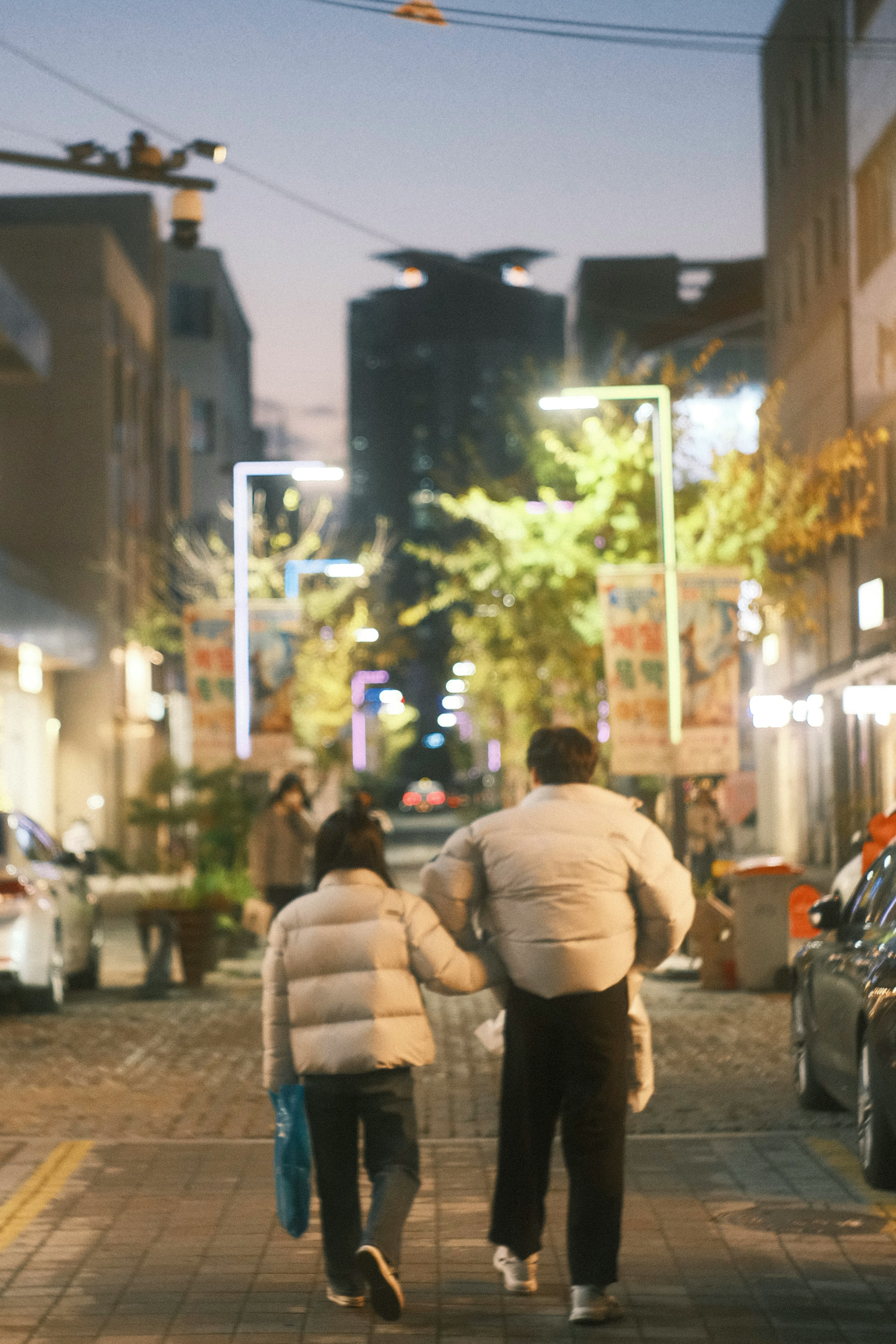 Silhouette orang tua dan anak berjalan di jalan malam