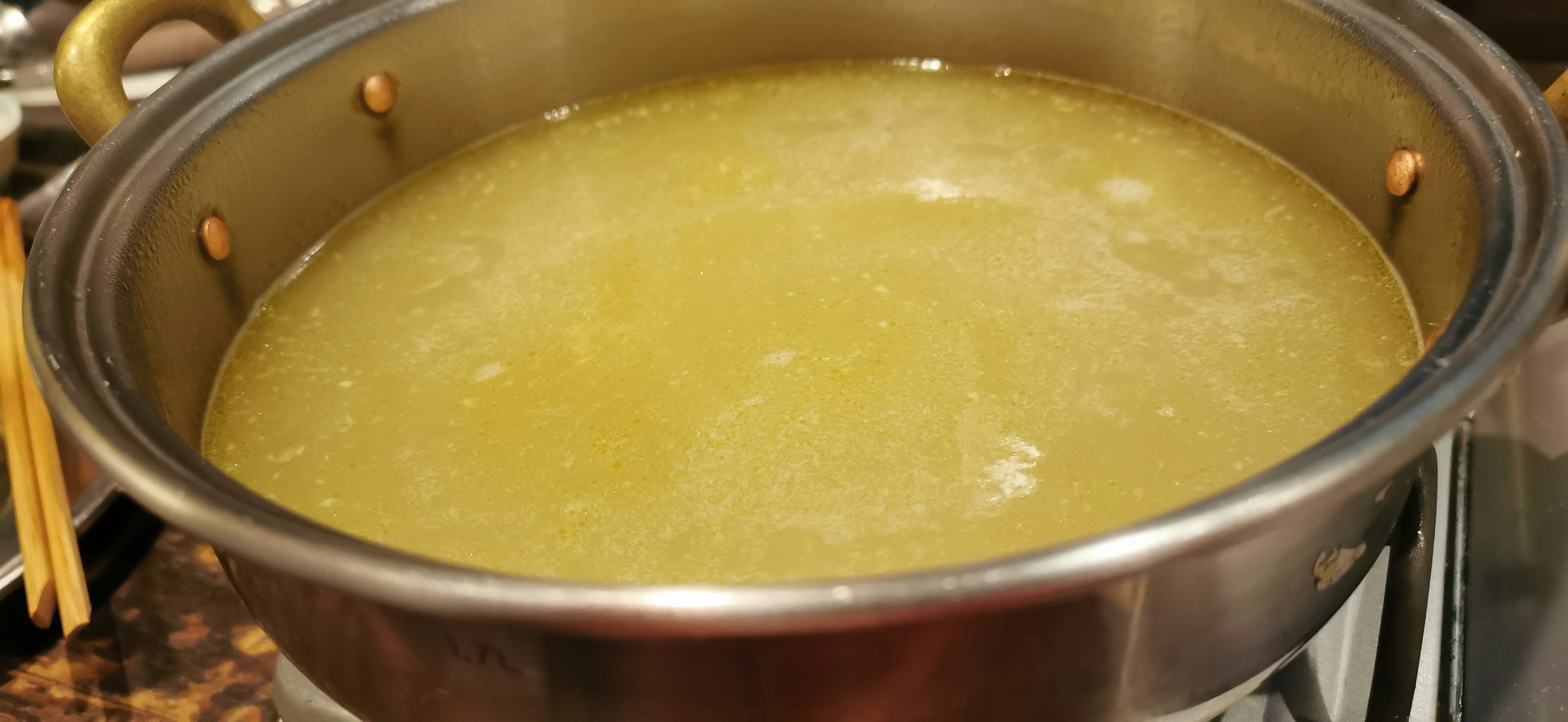 Clear broth in a metal pot