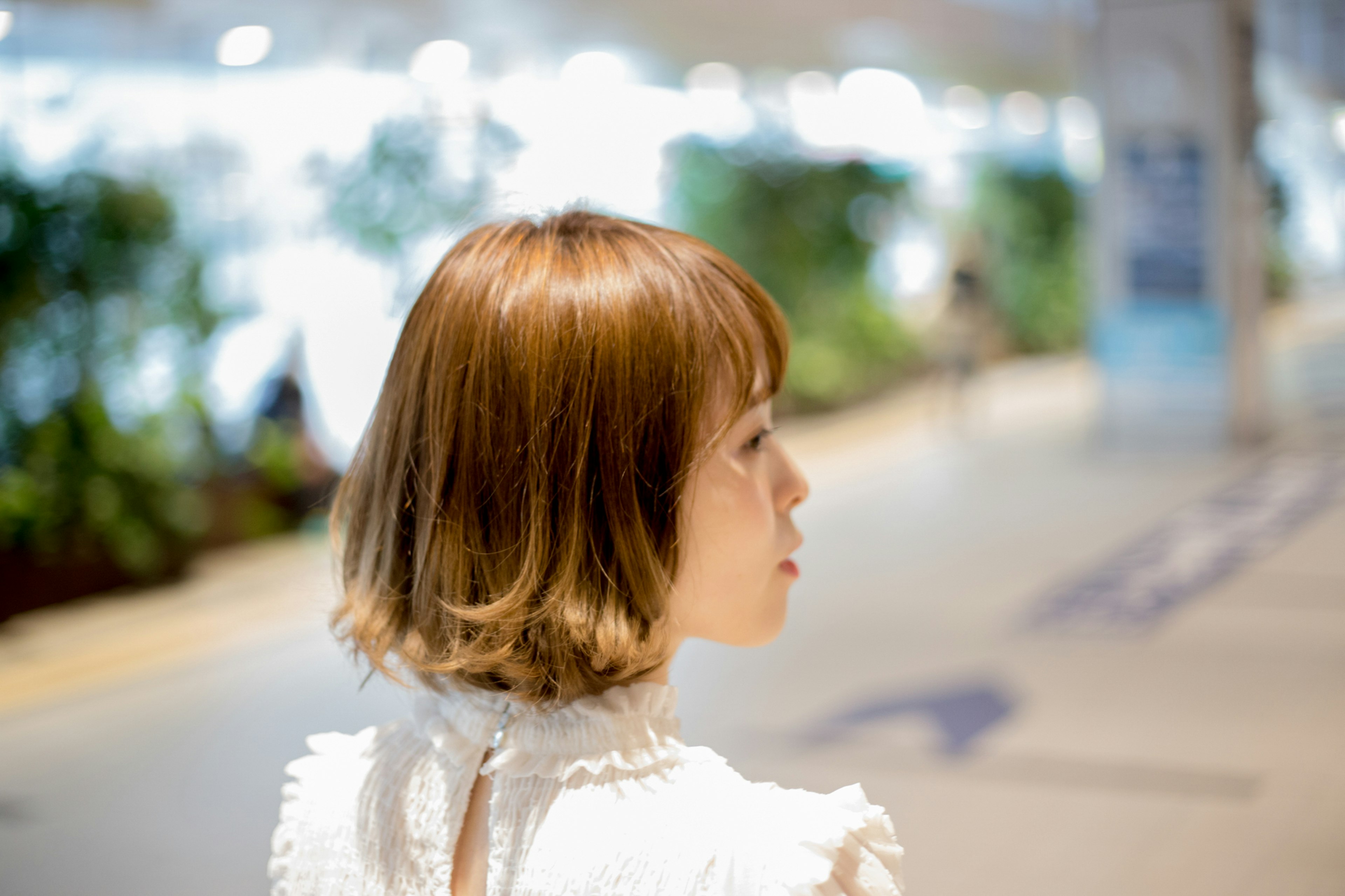 A woman with short brown hair seen from behind in an indoor setting