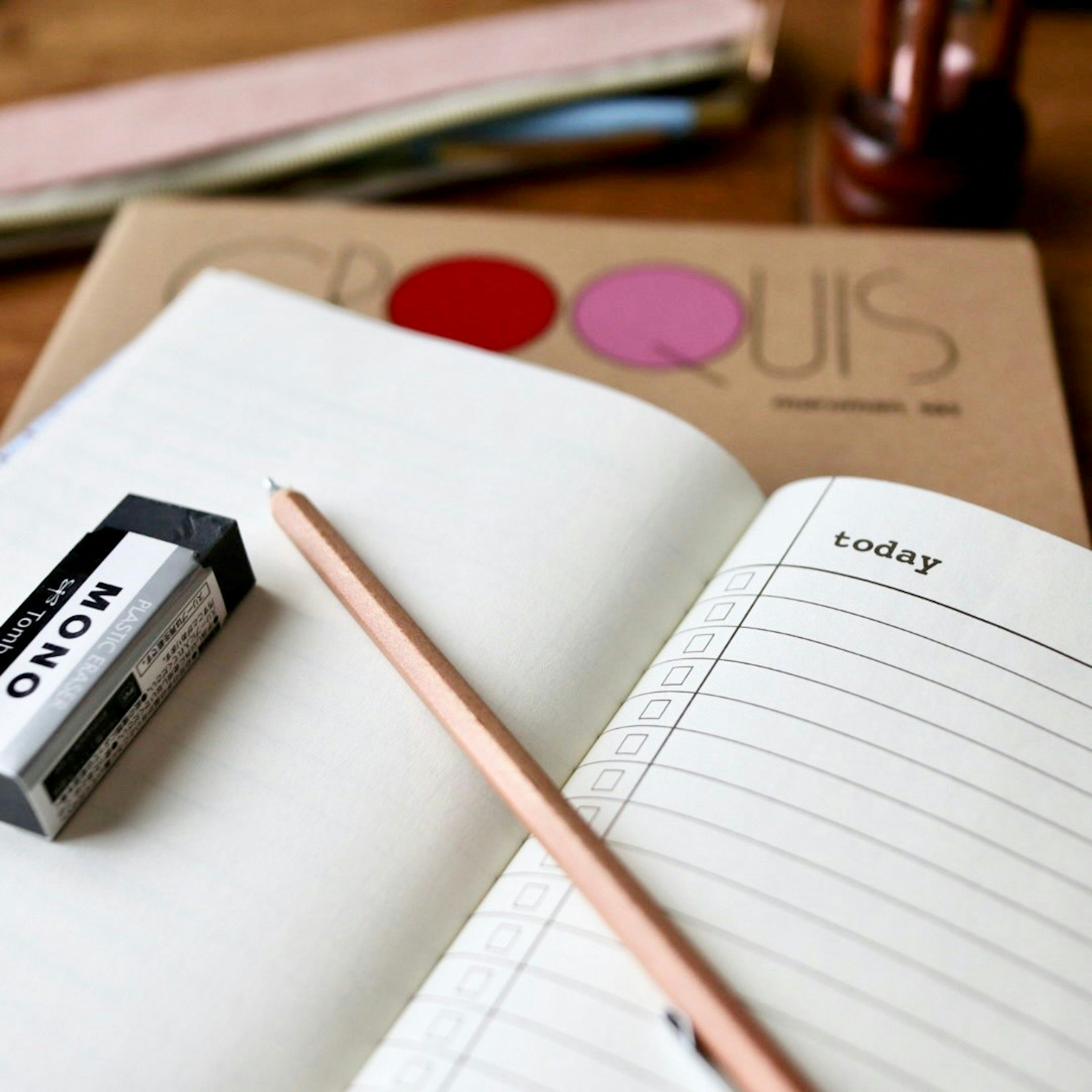 Image of a simple workspace featuring a notebook and a pencil