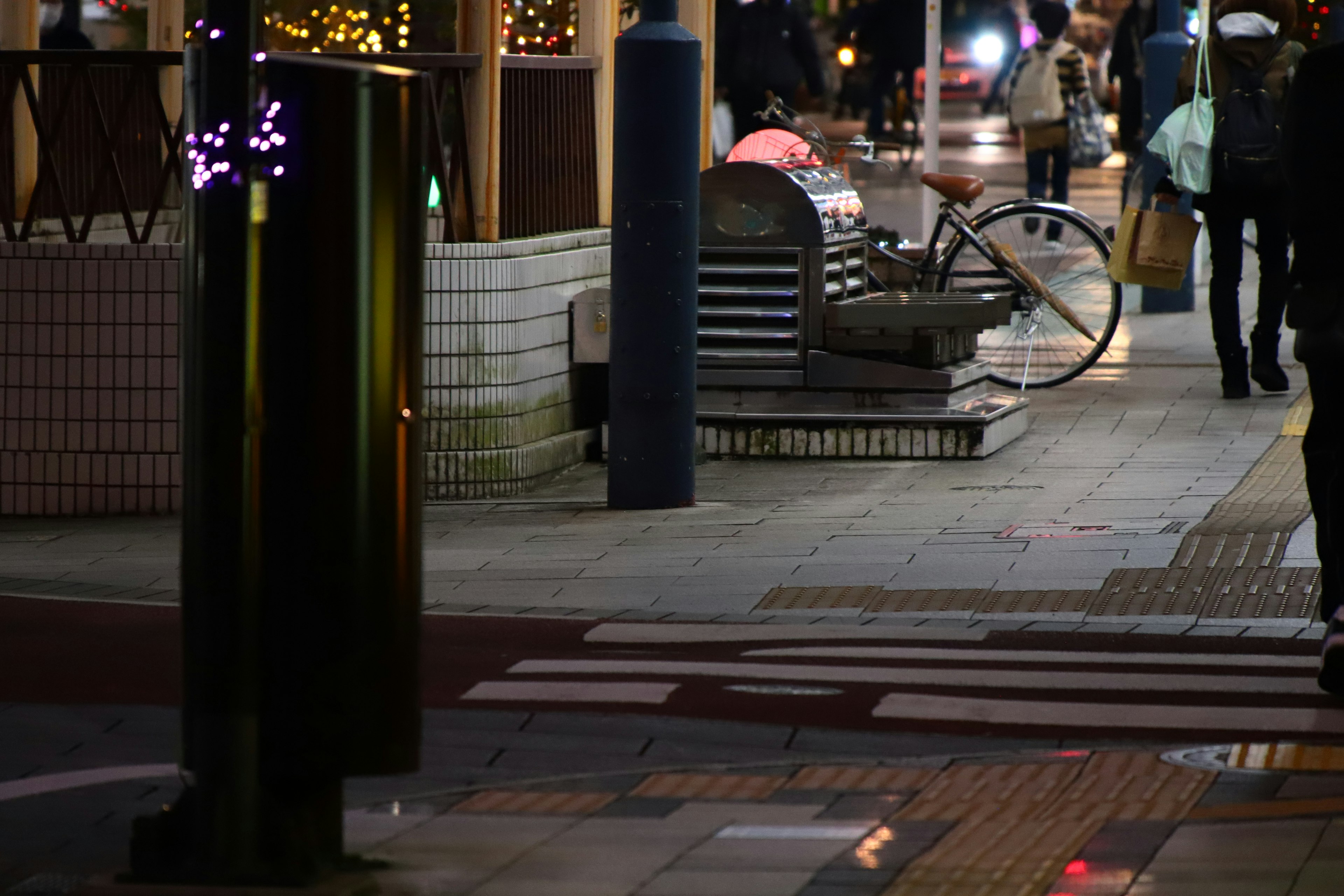 Scène de rue nocturne avec un banc et un vélo