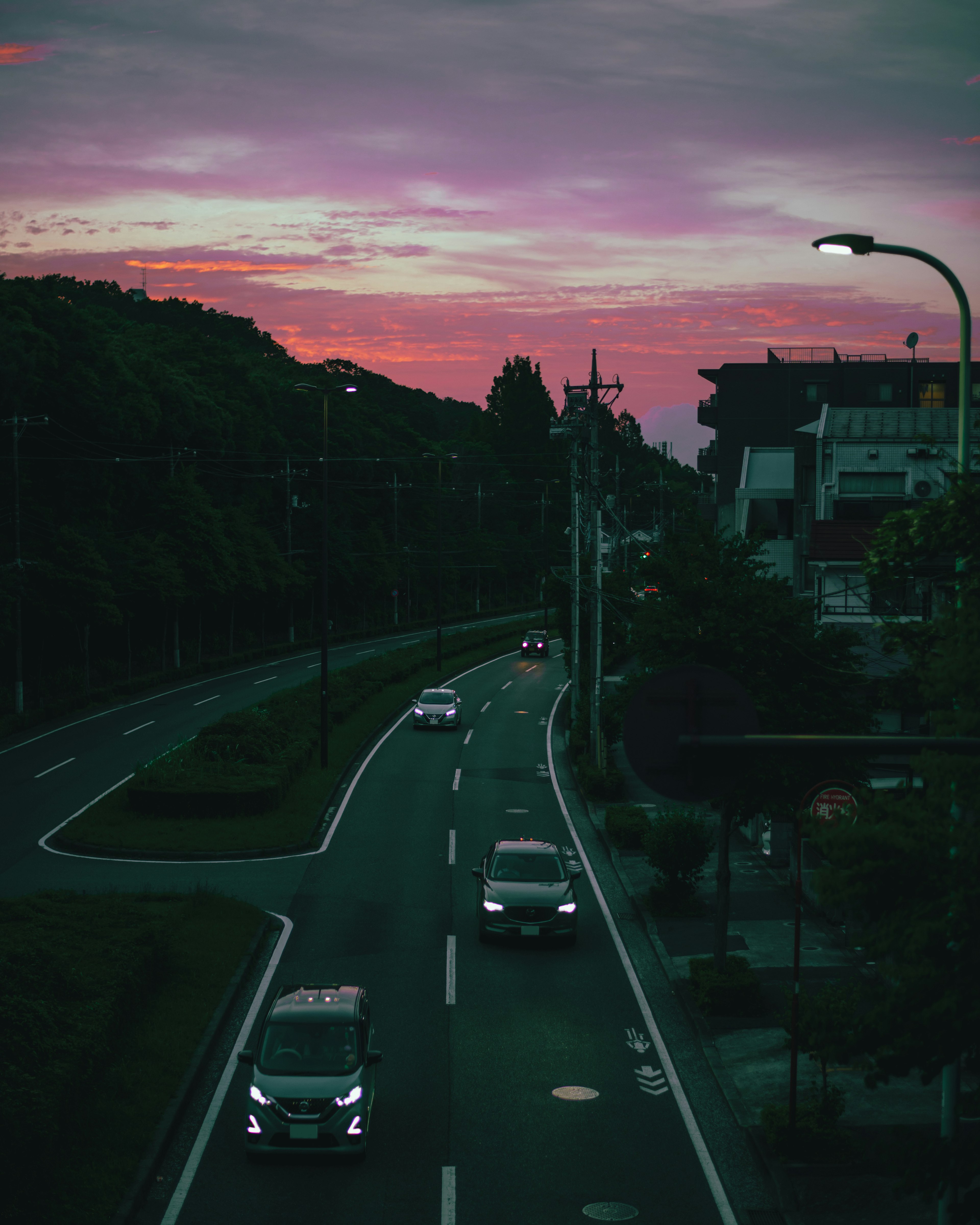 Strada con auto sotto un cielo al tramonto