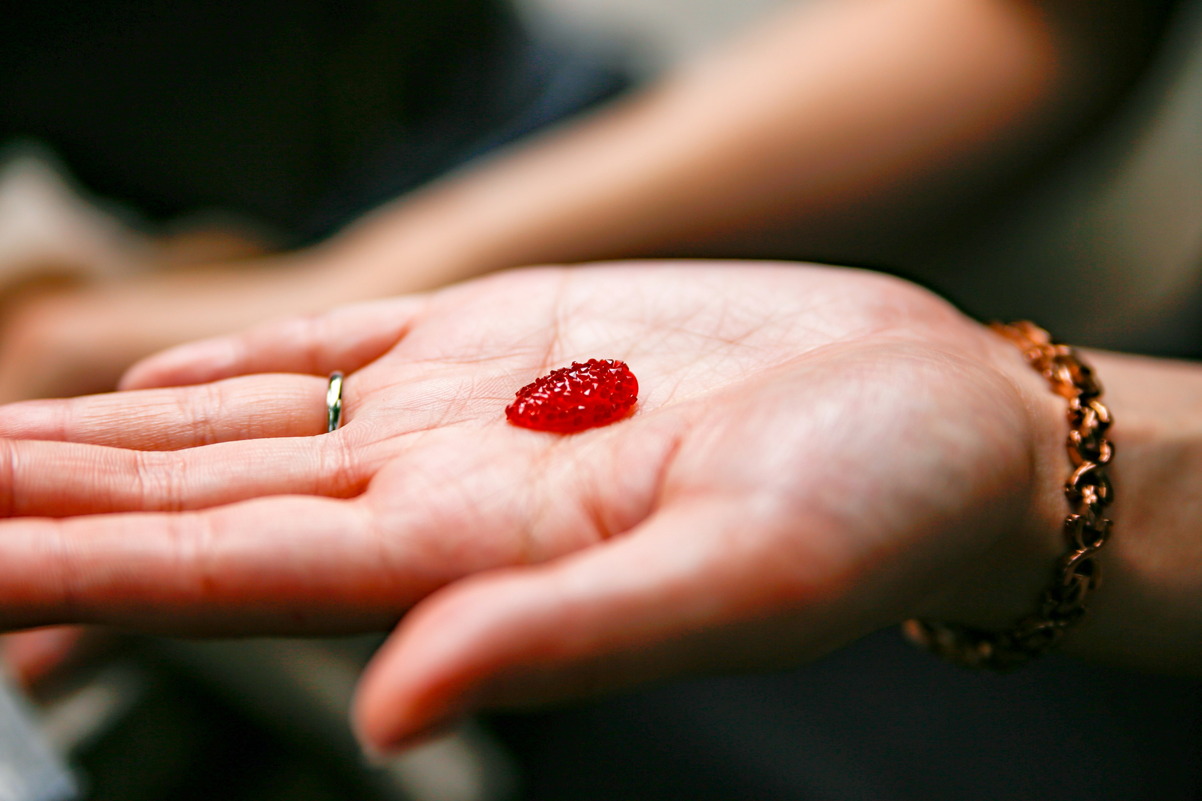 Una sostanza rossa simile a una gelatina posata su un palmo aperto