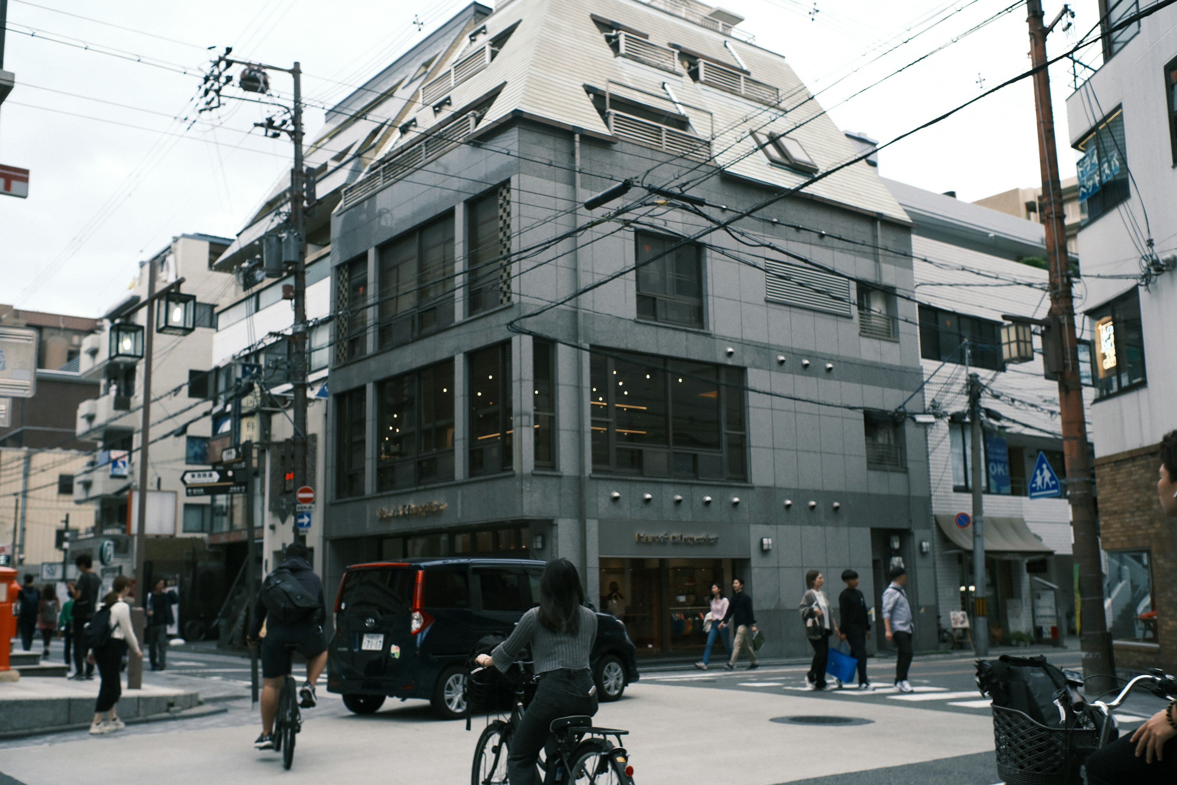 Edificio moderno en una intersección con bicicletas y peatones