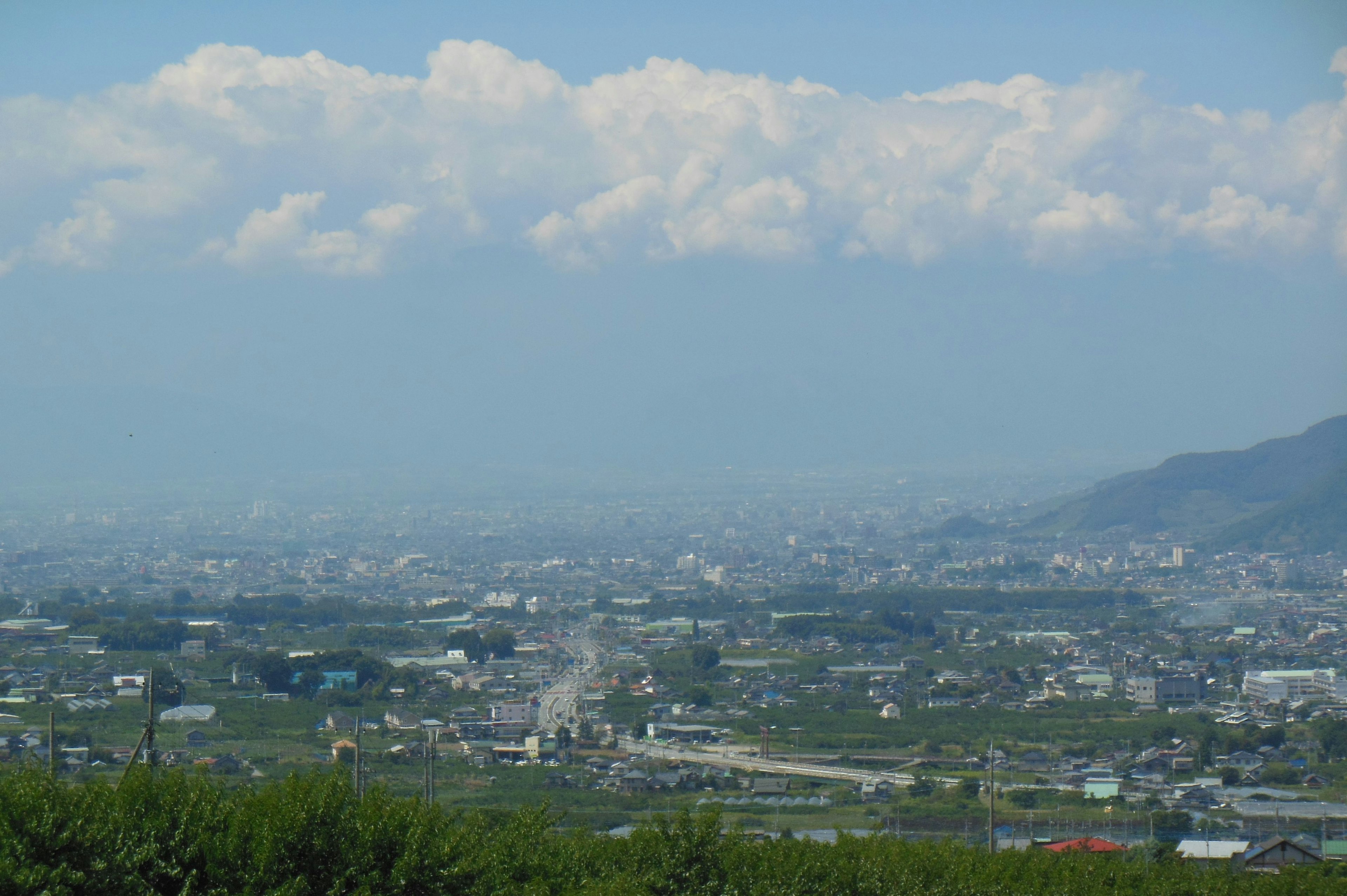 山々に囲まれた美しい風景と青い空が広がる