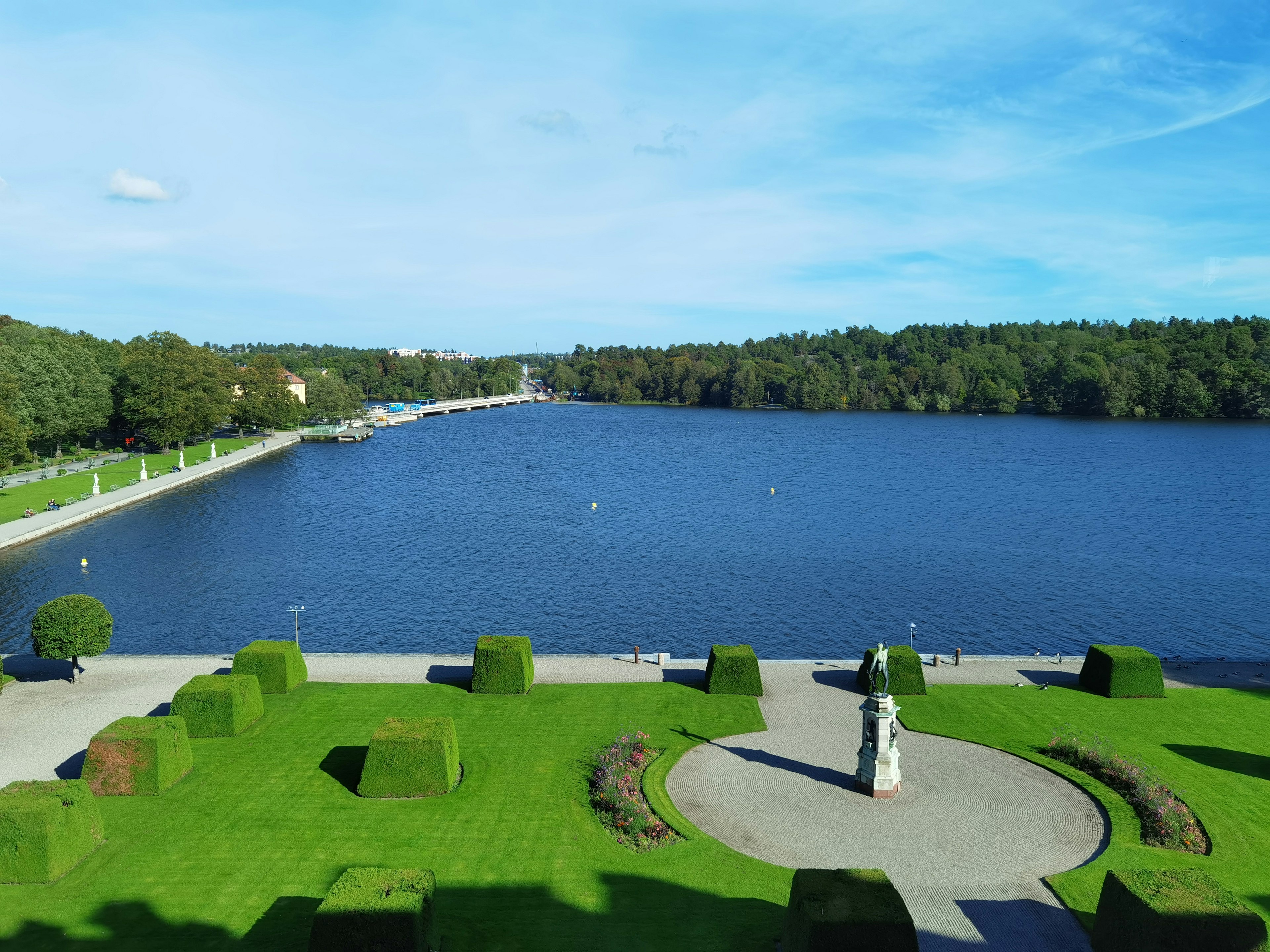 Vue d'un lac entouré d'herbe verte et d'une statue