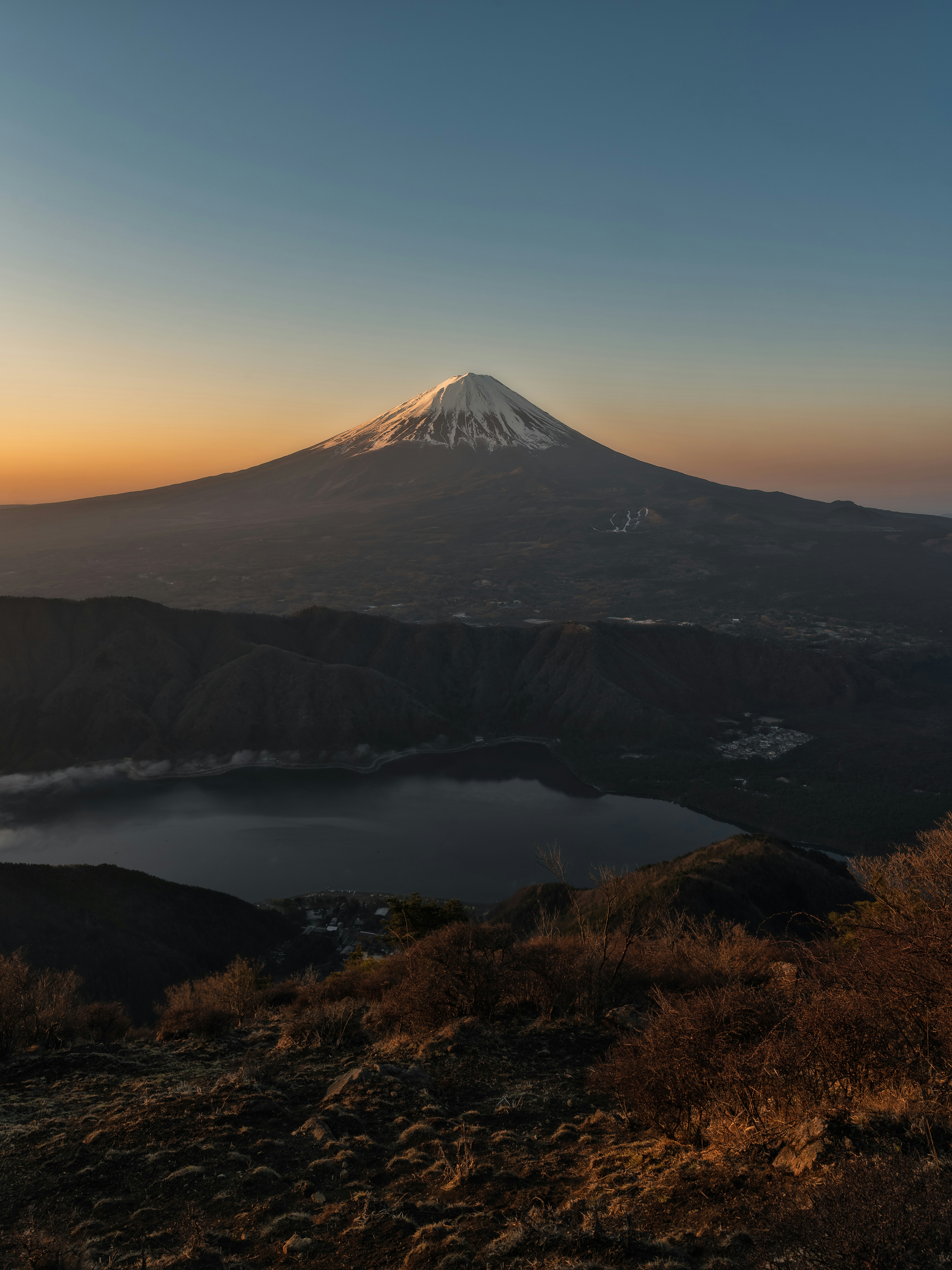 美しい夕焼けの中にそびえる雪をかぶった富士山の景色