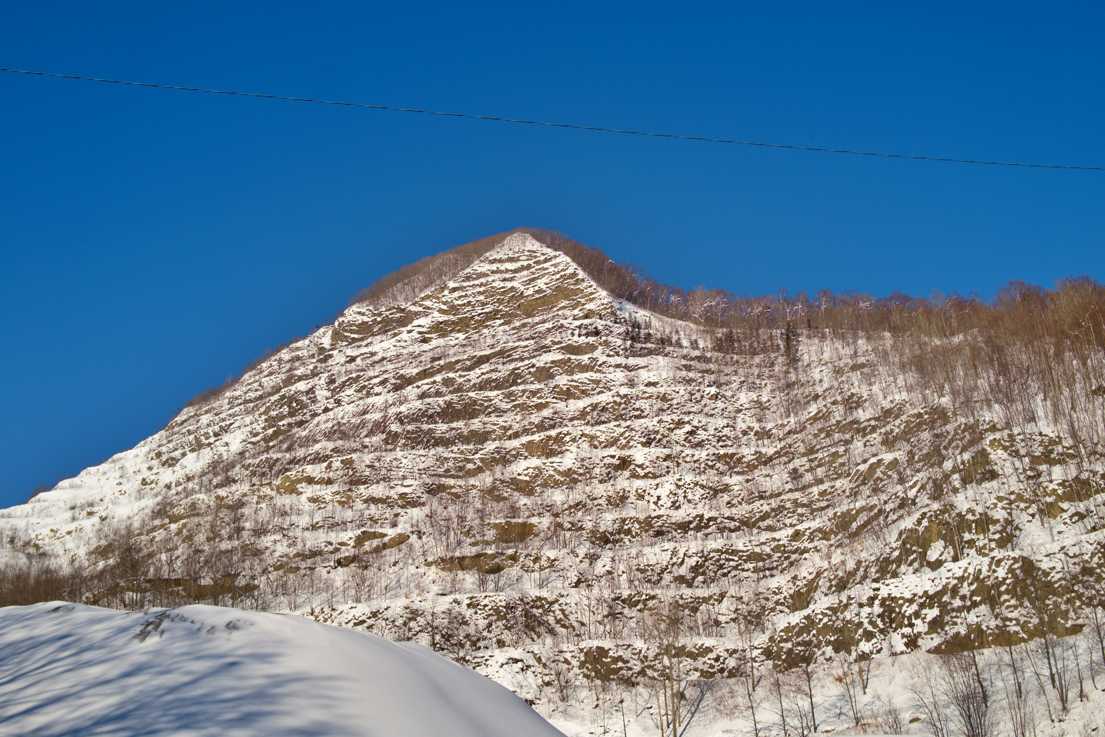 Schneebedeckte Bergabhänge mit klarem blauen Himmel