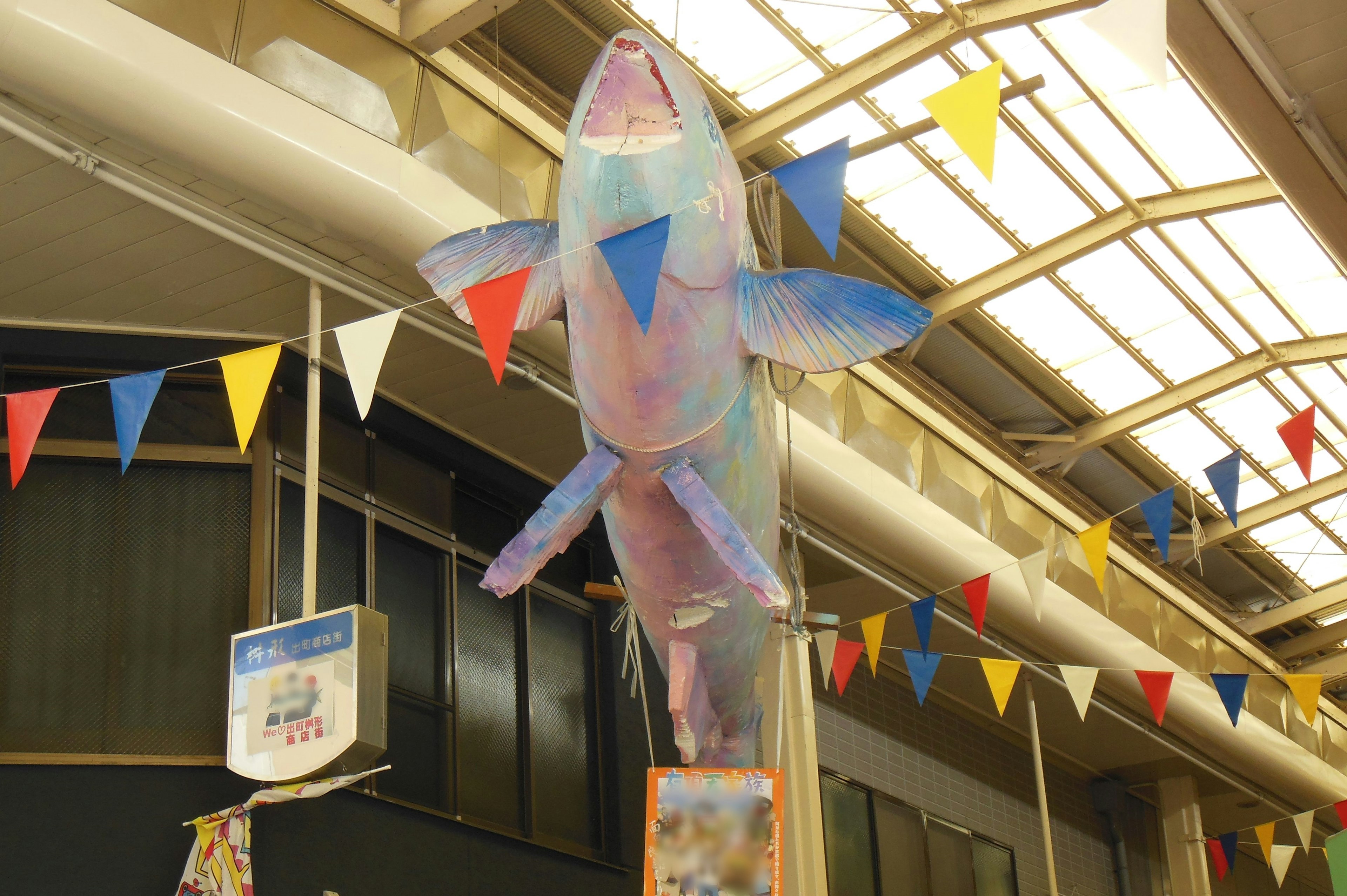 Große bunte Fischdekoration, die von der Decke hängt