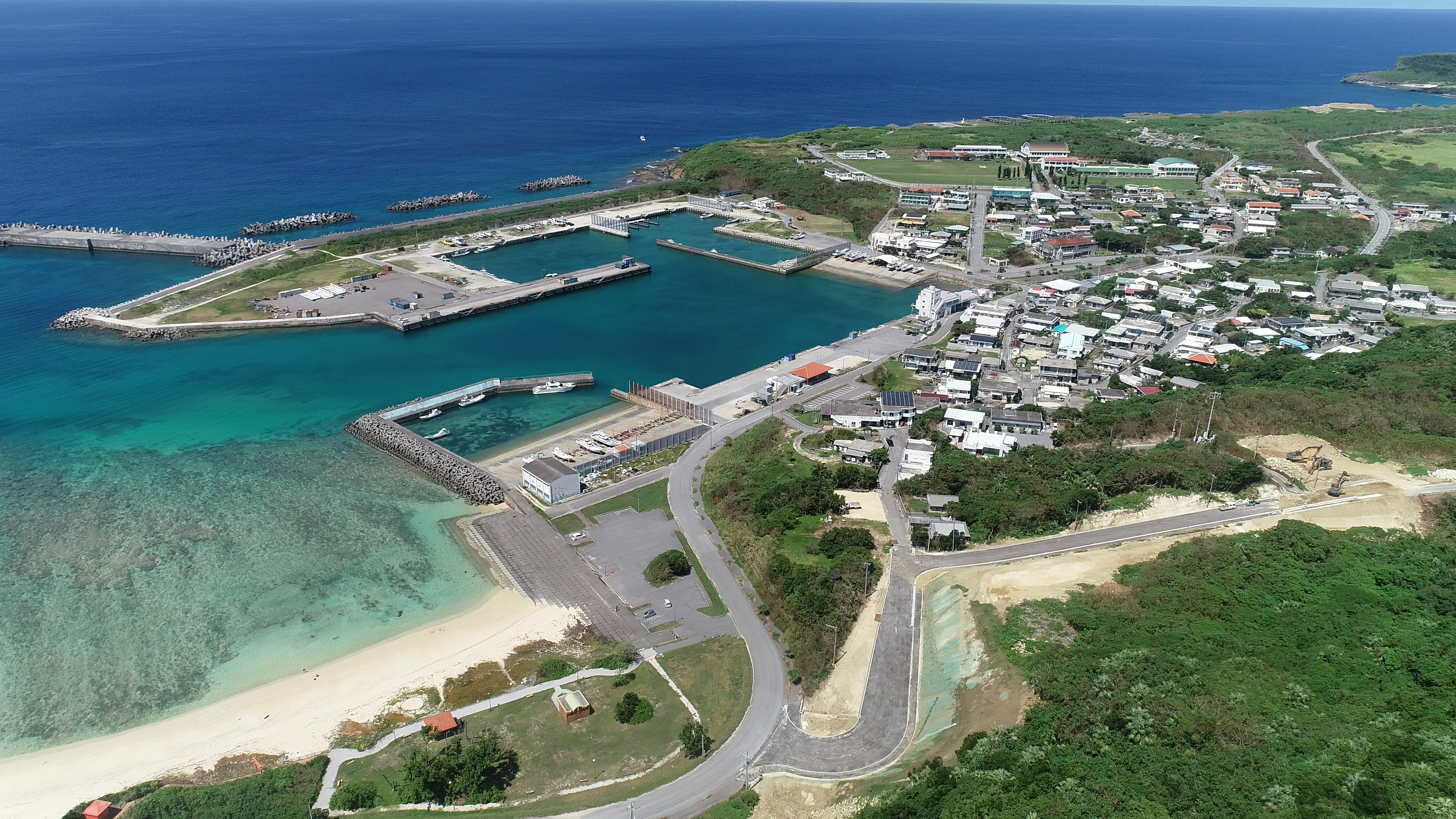 青い海と緑の土地に囲まれた小さな港町の空撮