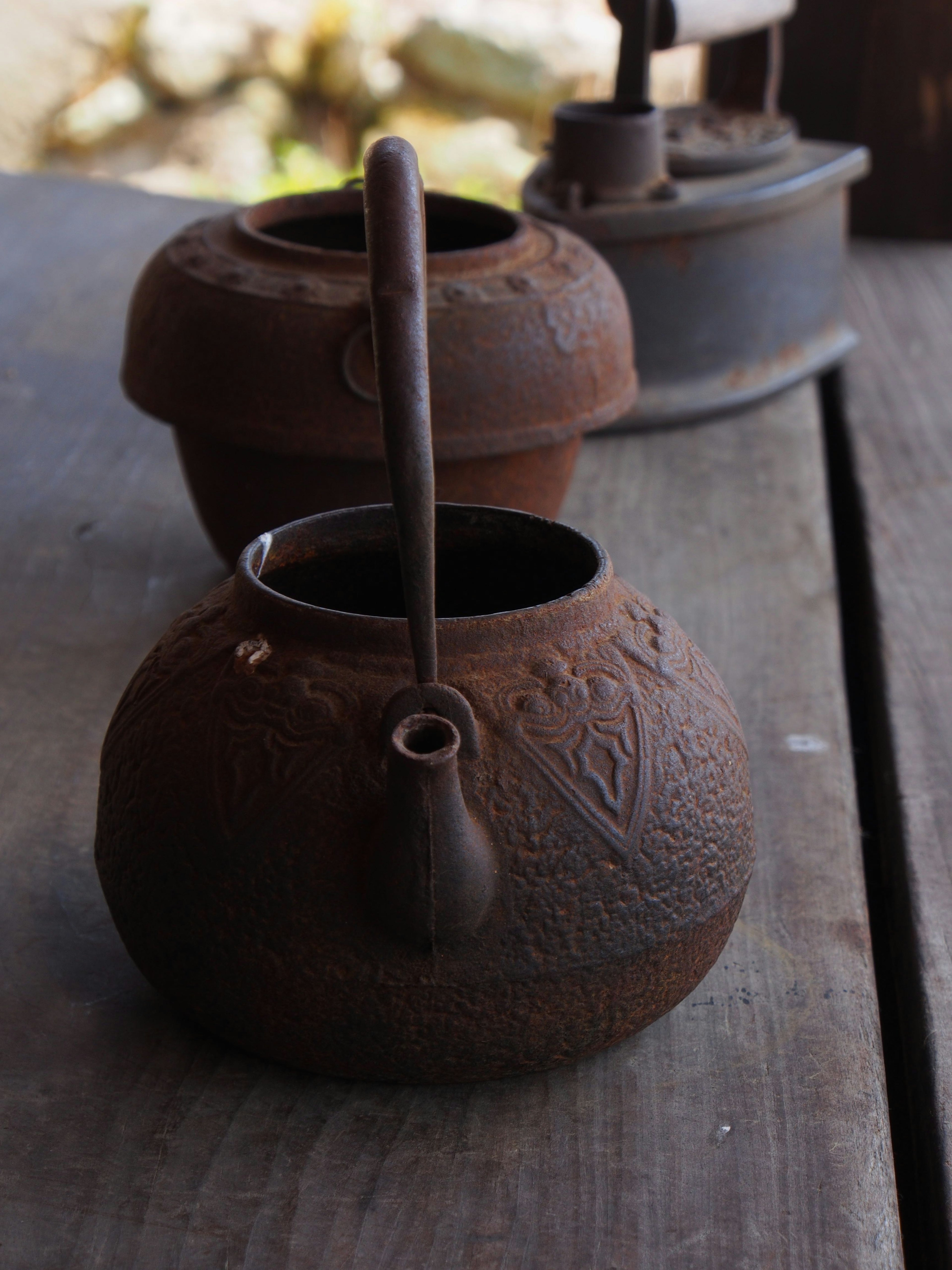 An old iron kettle placed on a wooden table