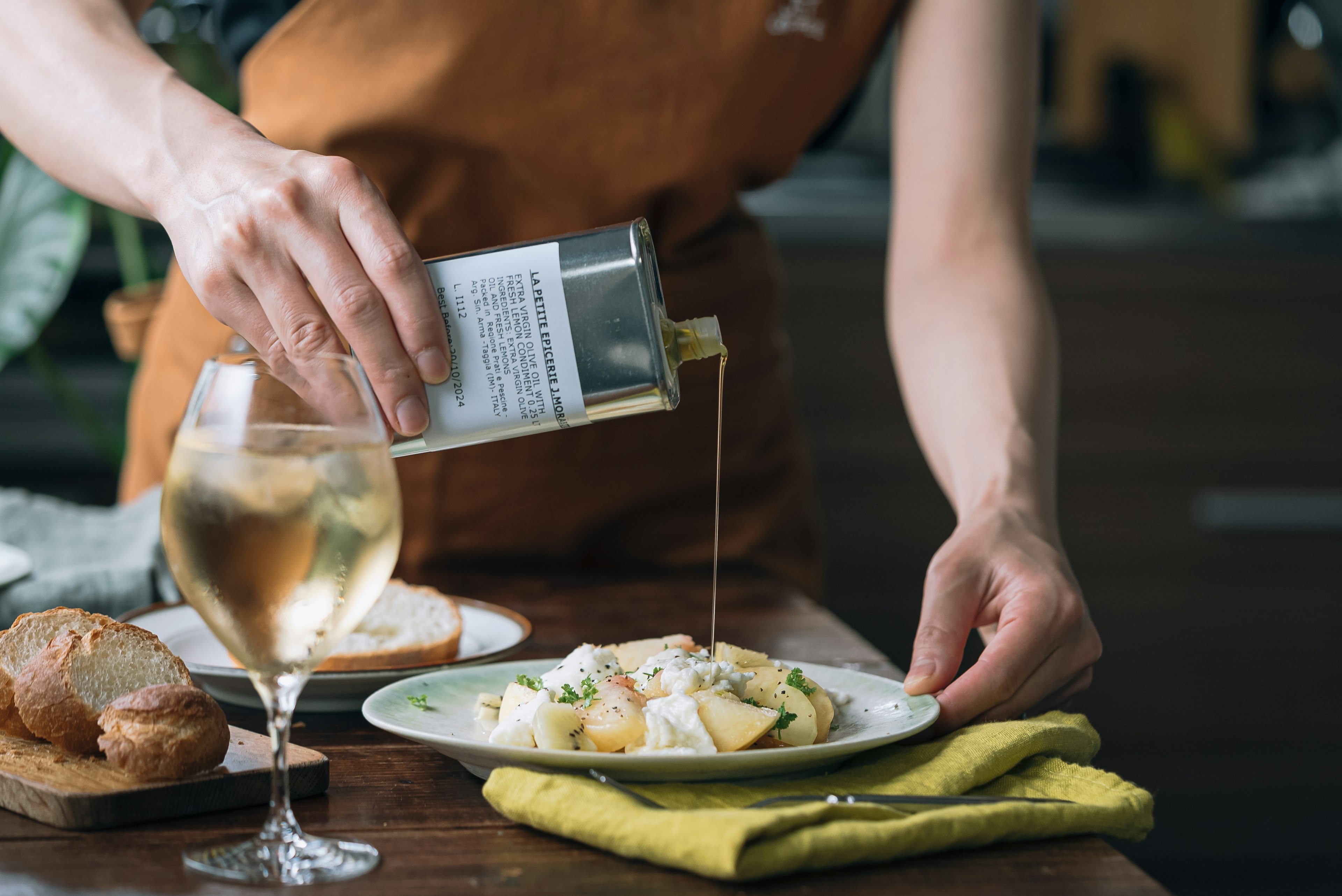 Personne versant de l'huile d'olive sur un plat dans un cadre de cuisine