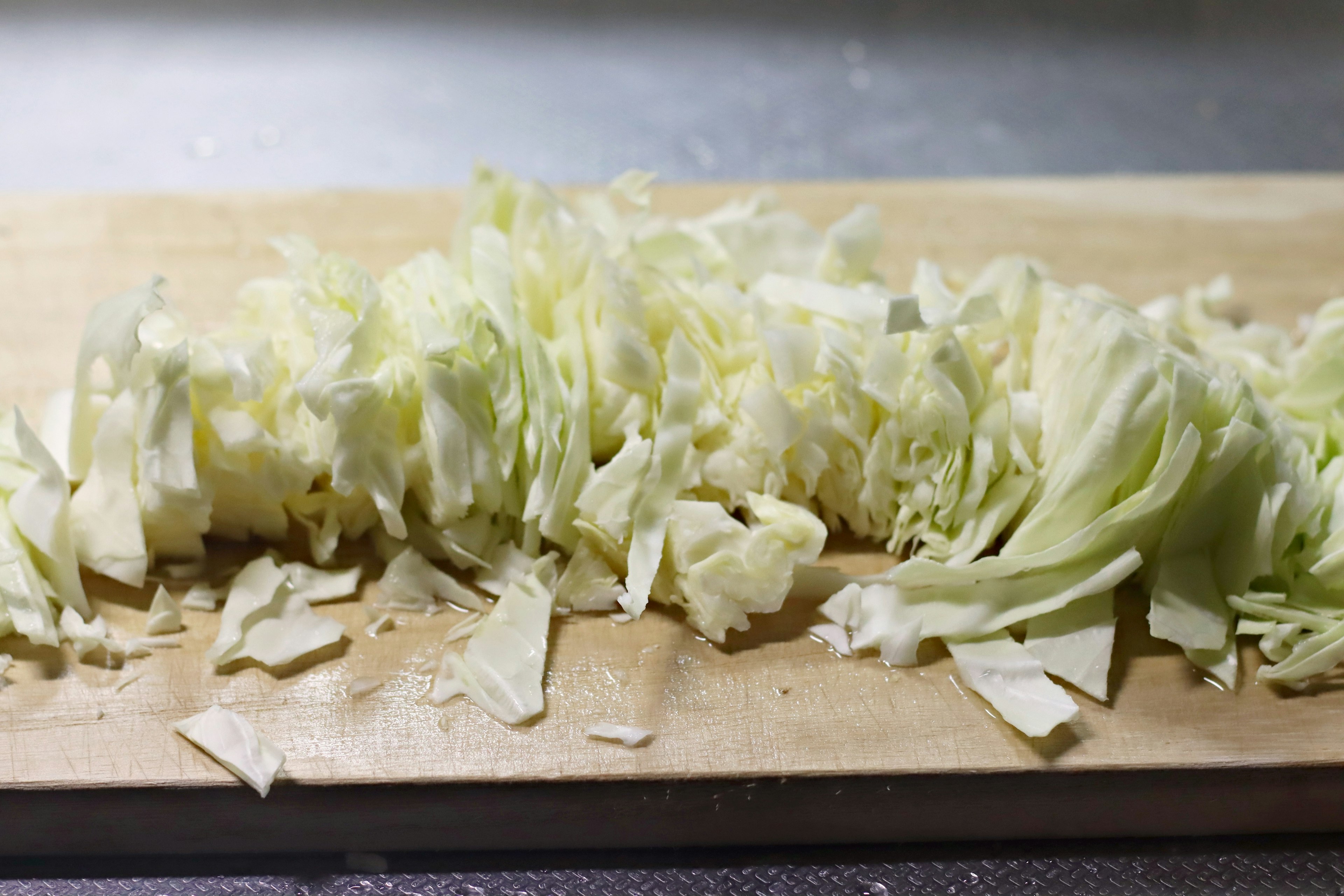 Chopped cabbage arranged on a wooden cutting board