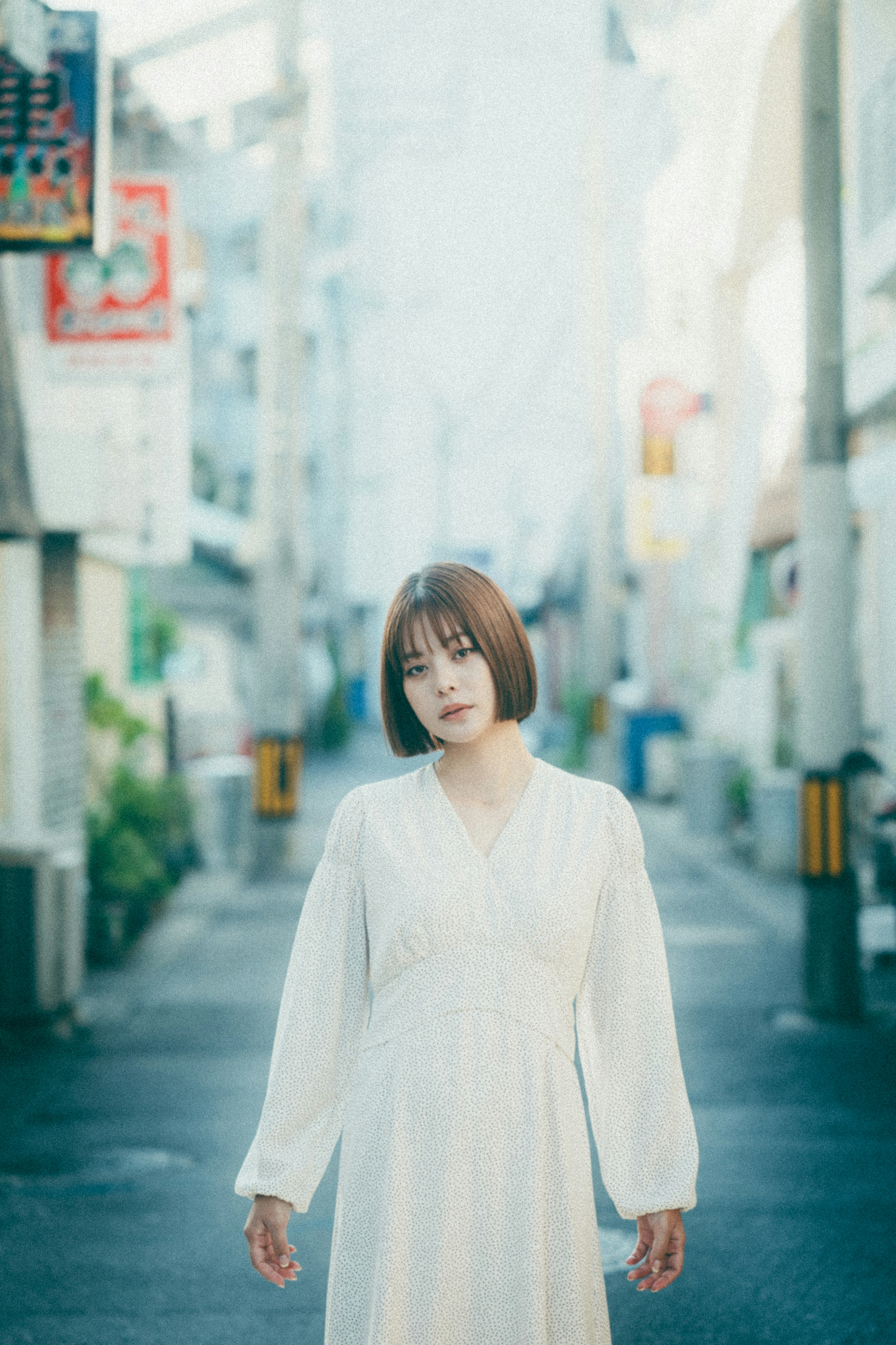 Woman in a white dress walking in a quiet alley