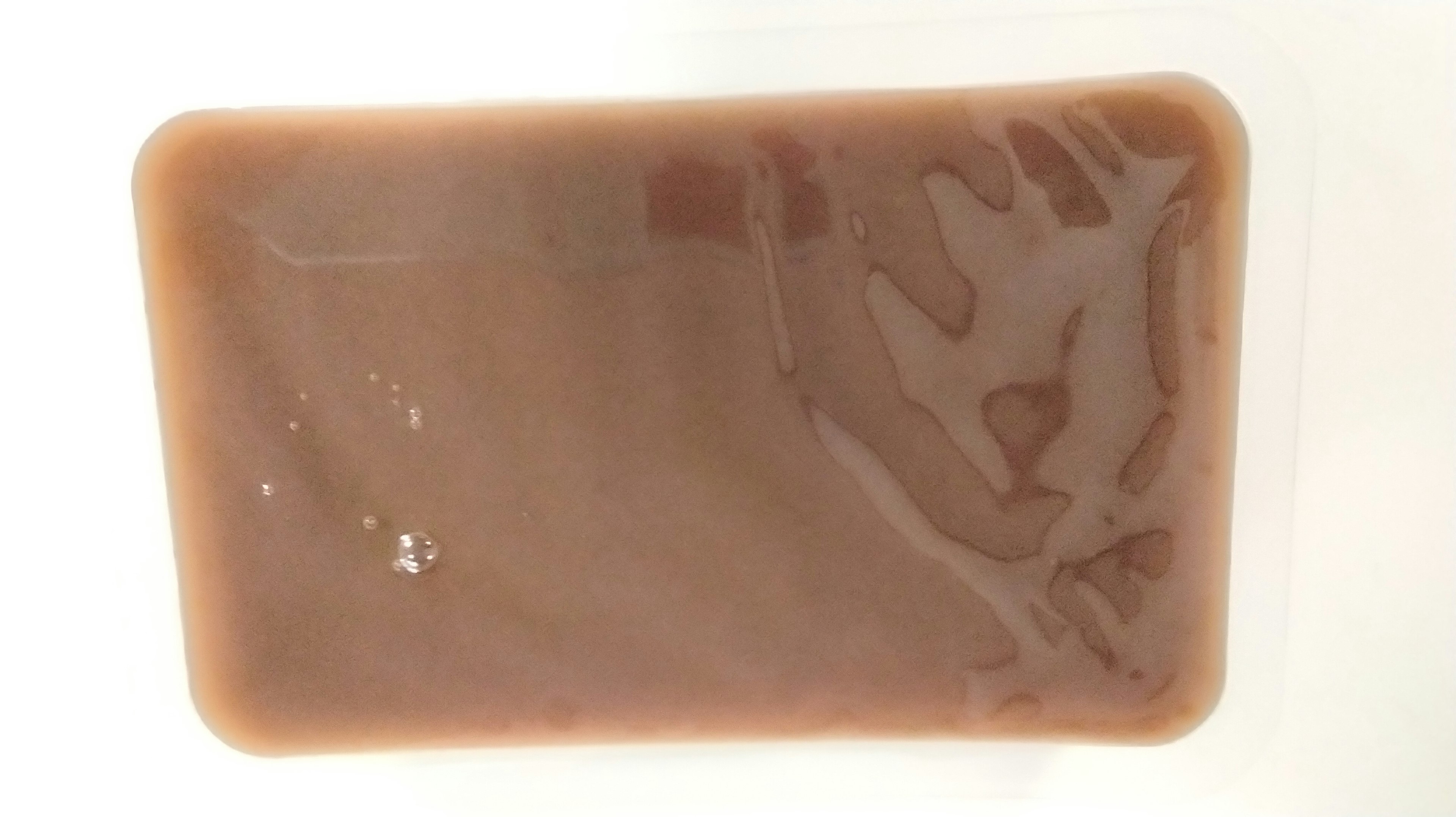 A rectangular container filled with brown liquid