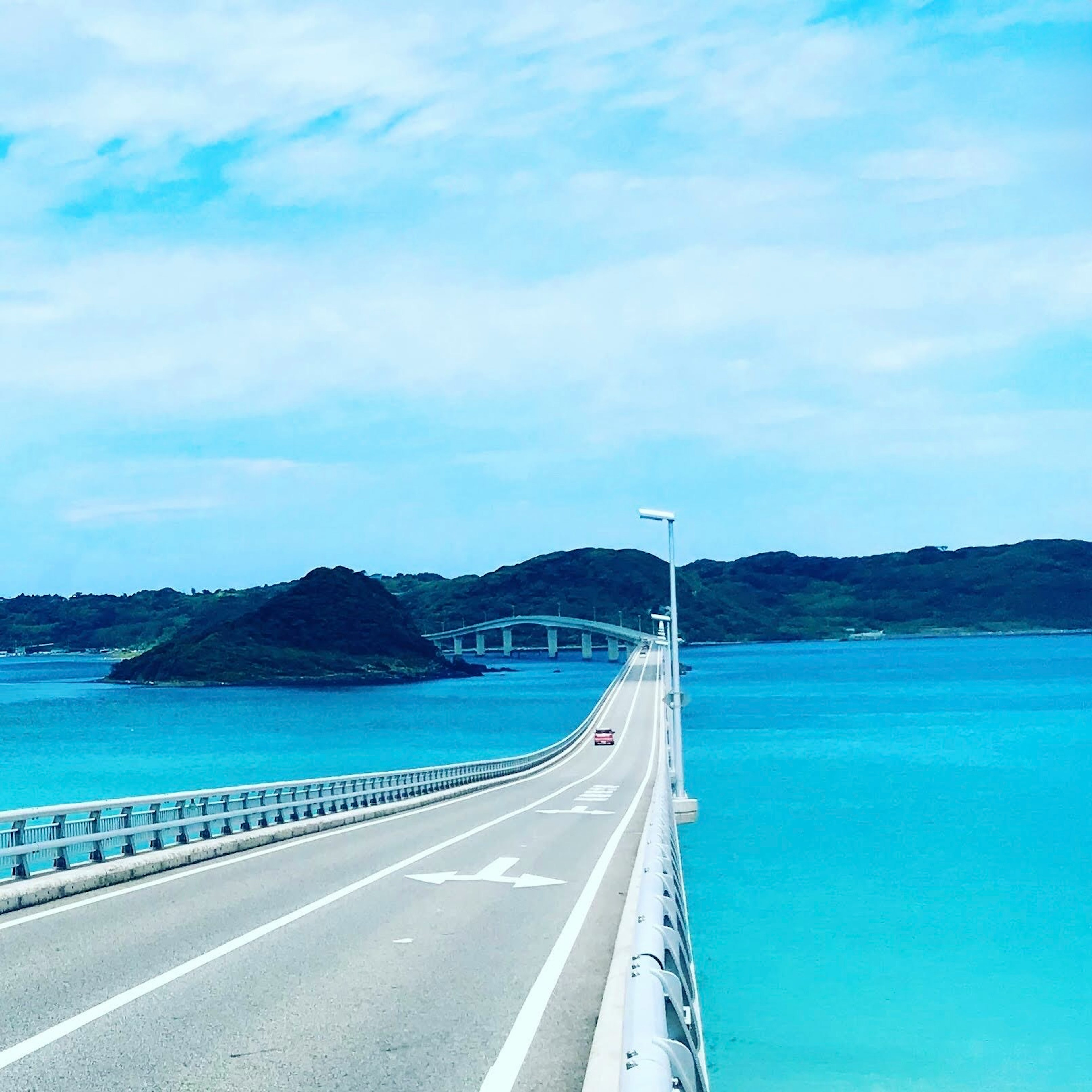 Schöner Brücke über türkisfarbenem Meer mit einer kleinen Insel