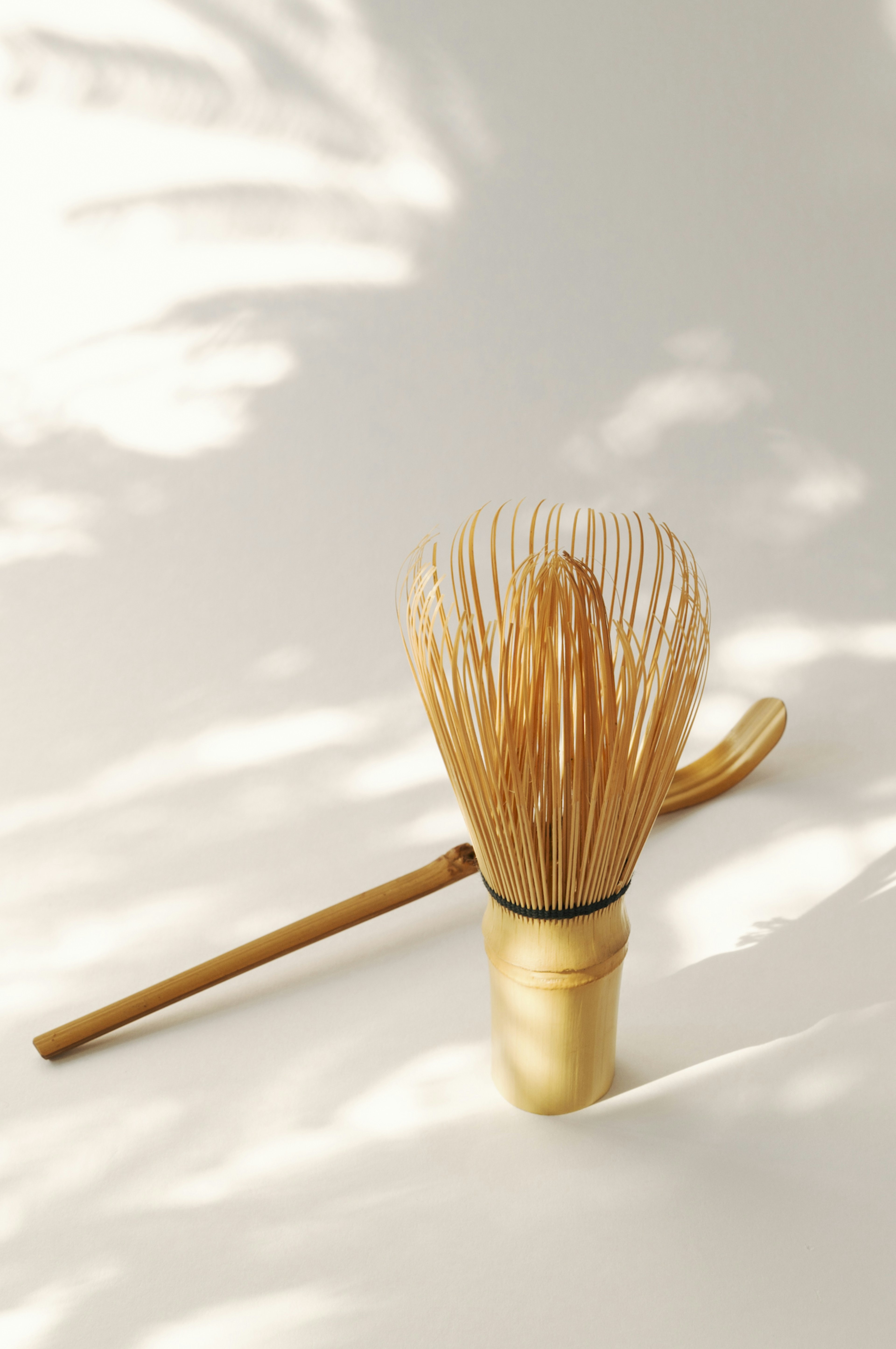 Bamboo matcha whisk and scoop set on a white background