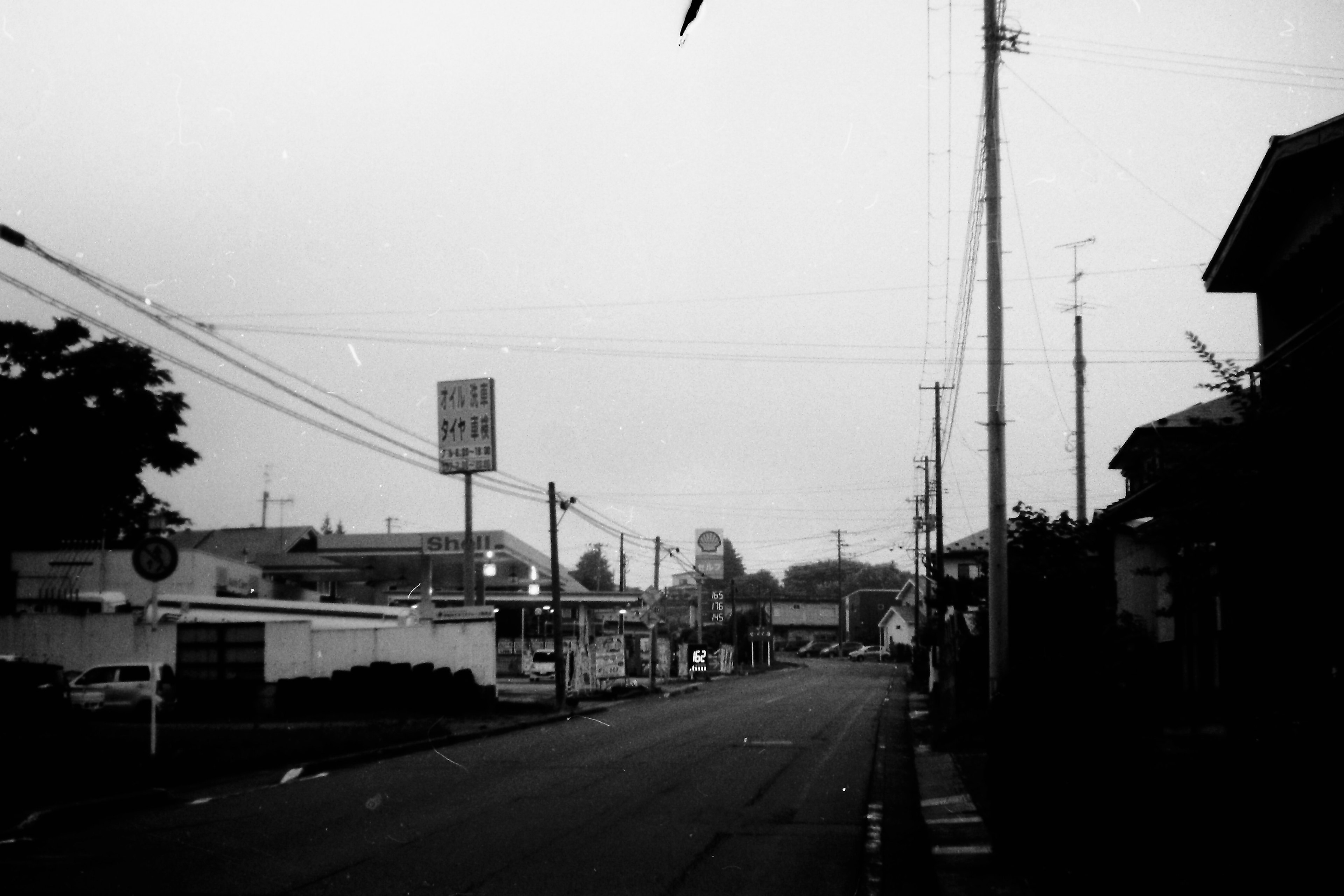 Black and white street view with power lines and buildings