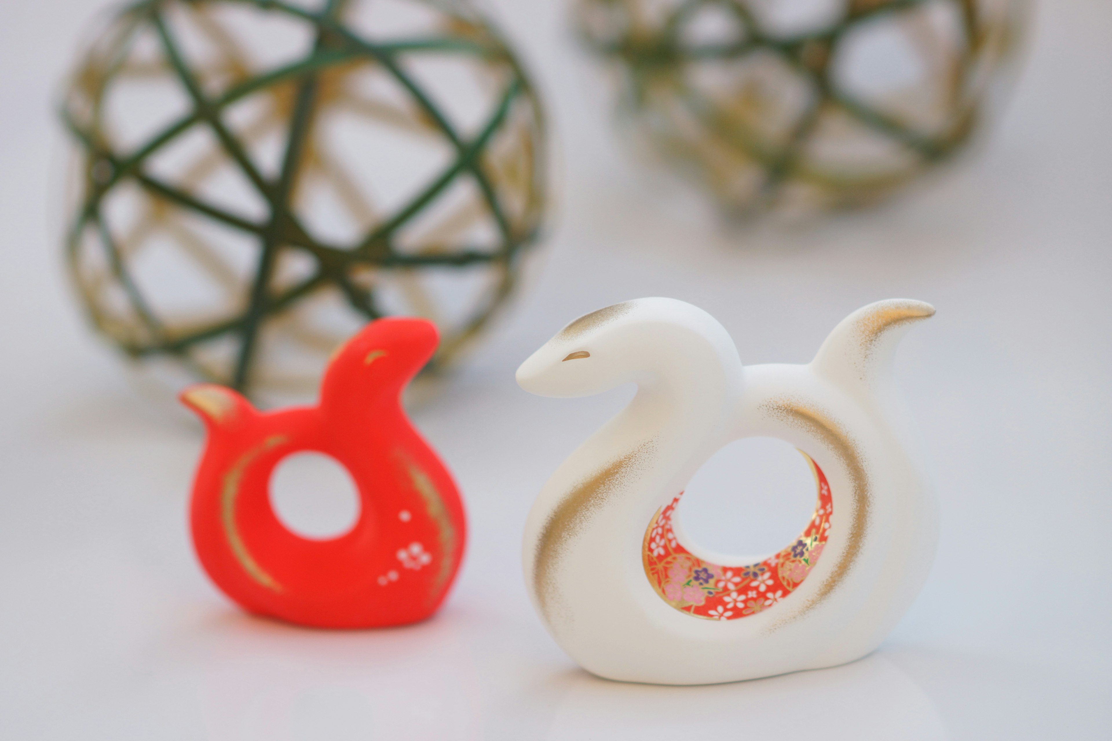 Red and white bird figurines with decorative spheres in the background