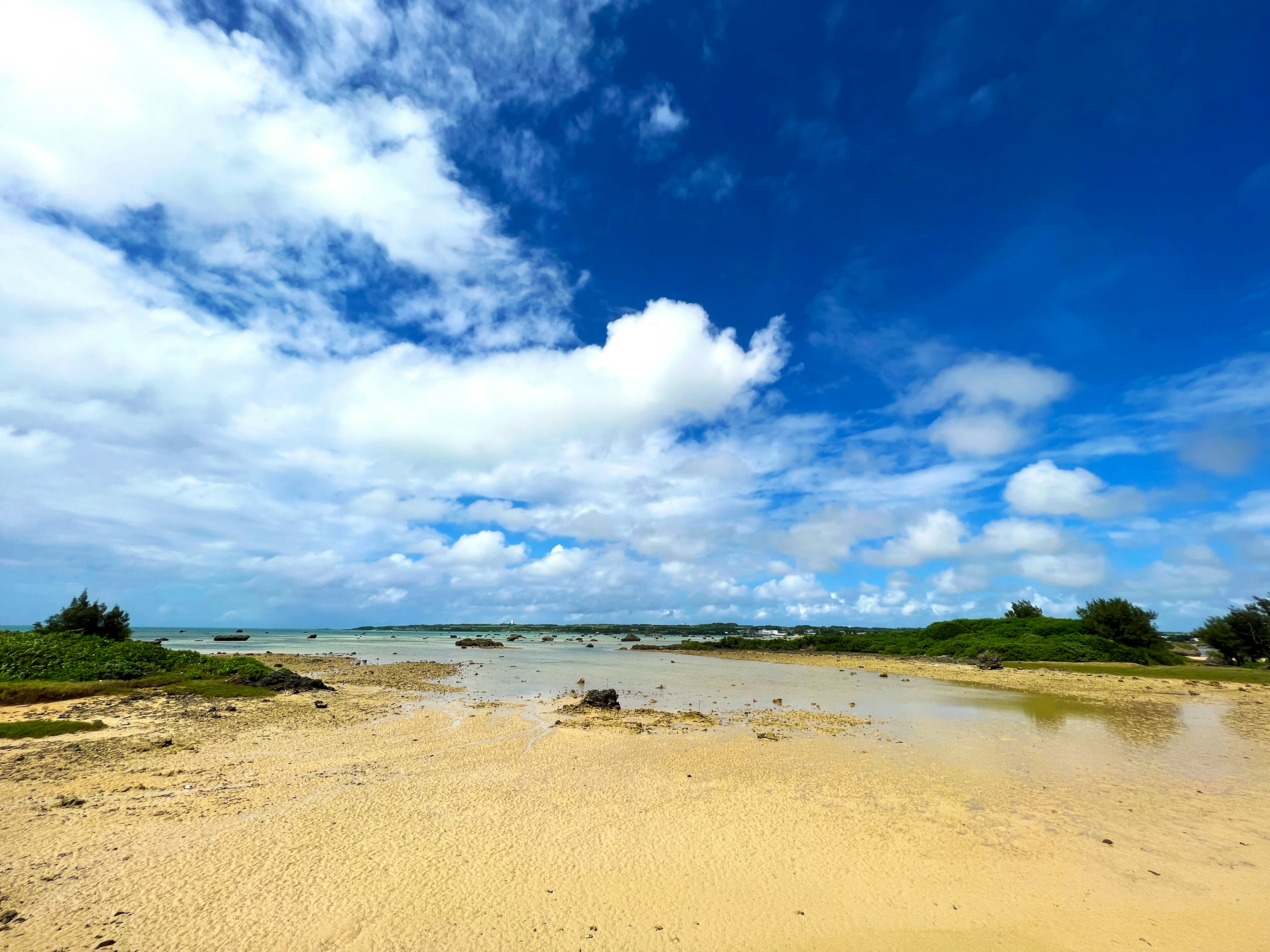 Vista panoramica della spiaggia con cielo blu e nuvole bianche