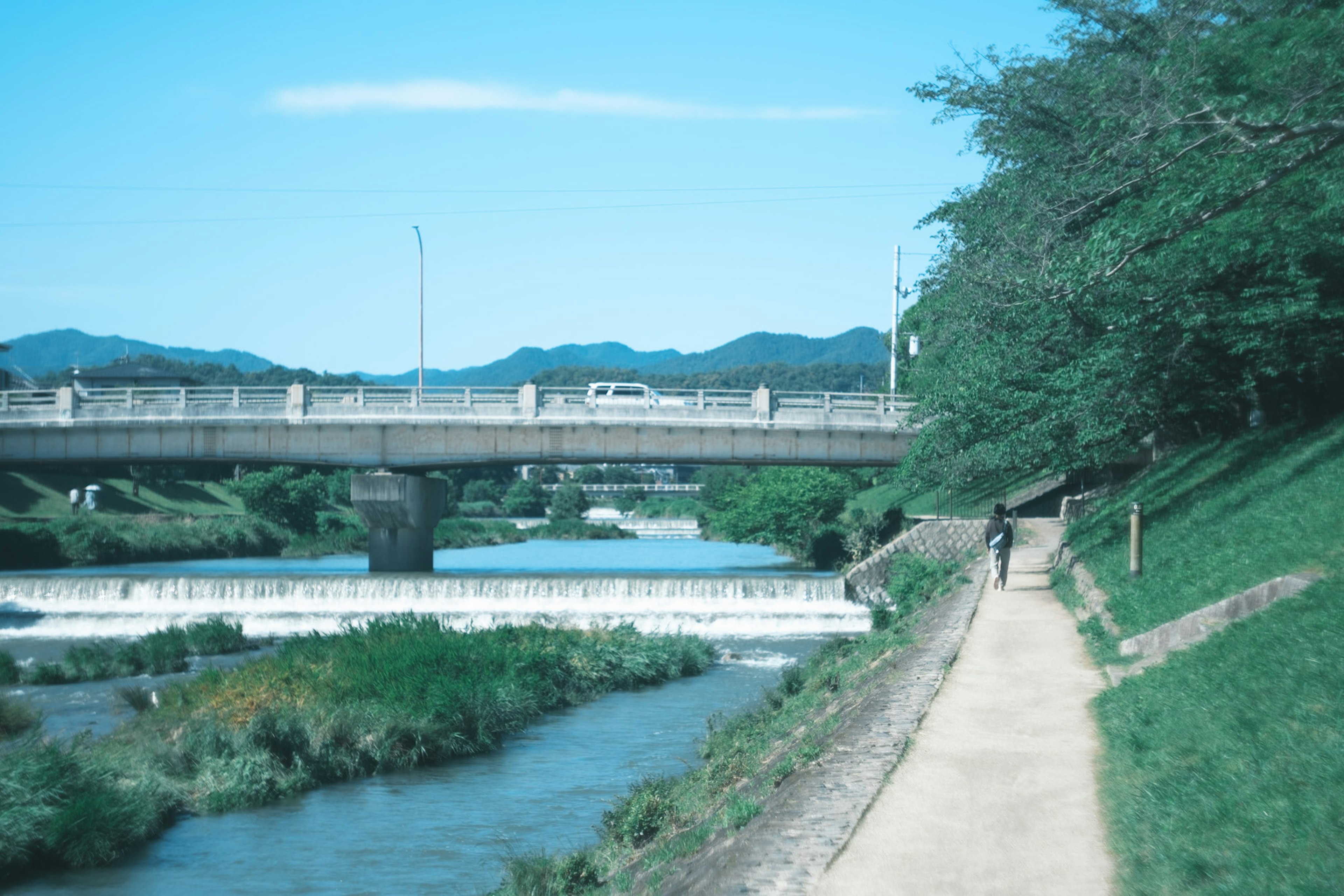 Scenic view of a river and a bridge with a pathway