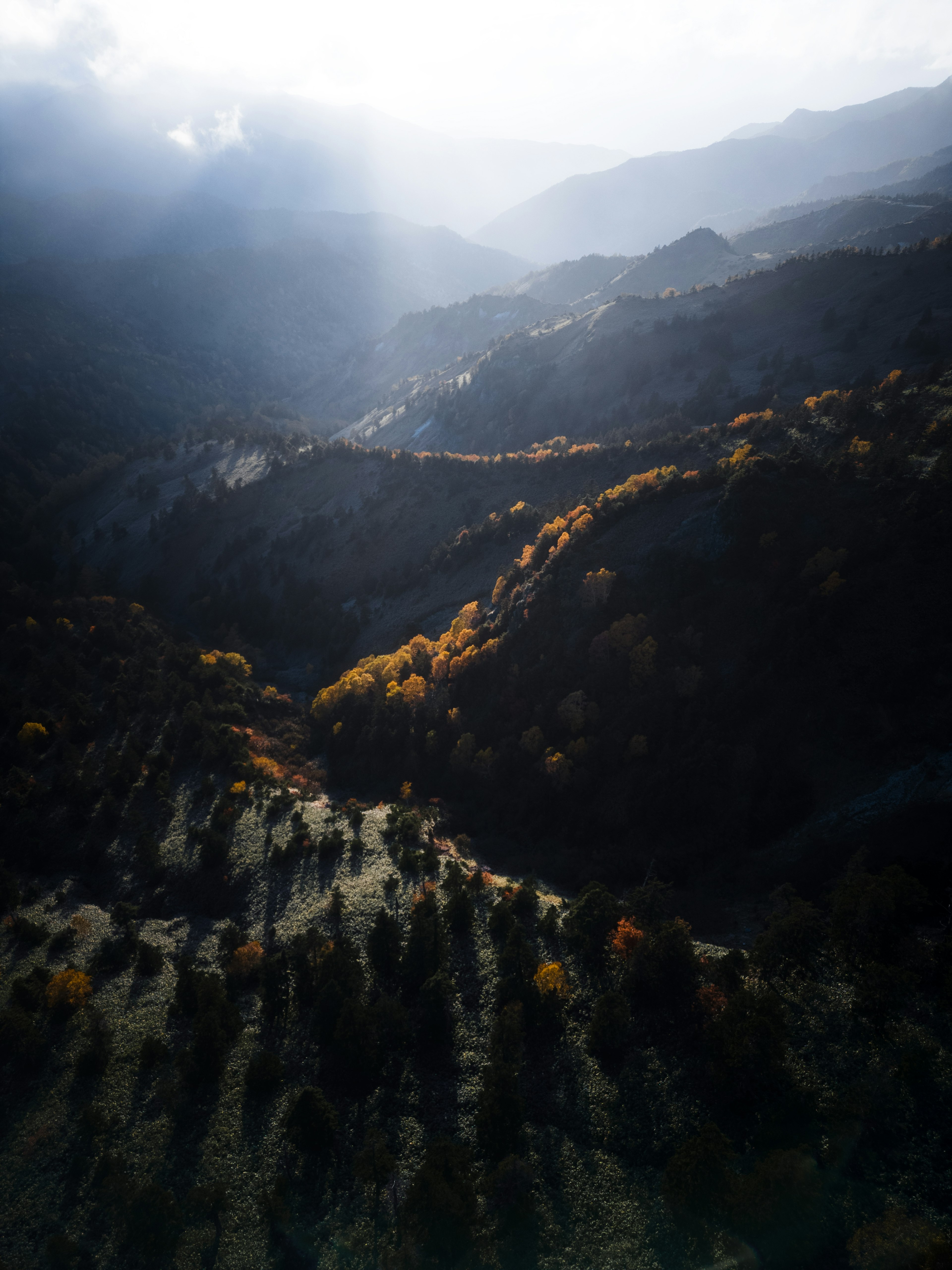 山々の間に広がる秋の風景と光の差し込み