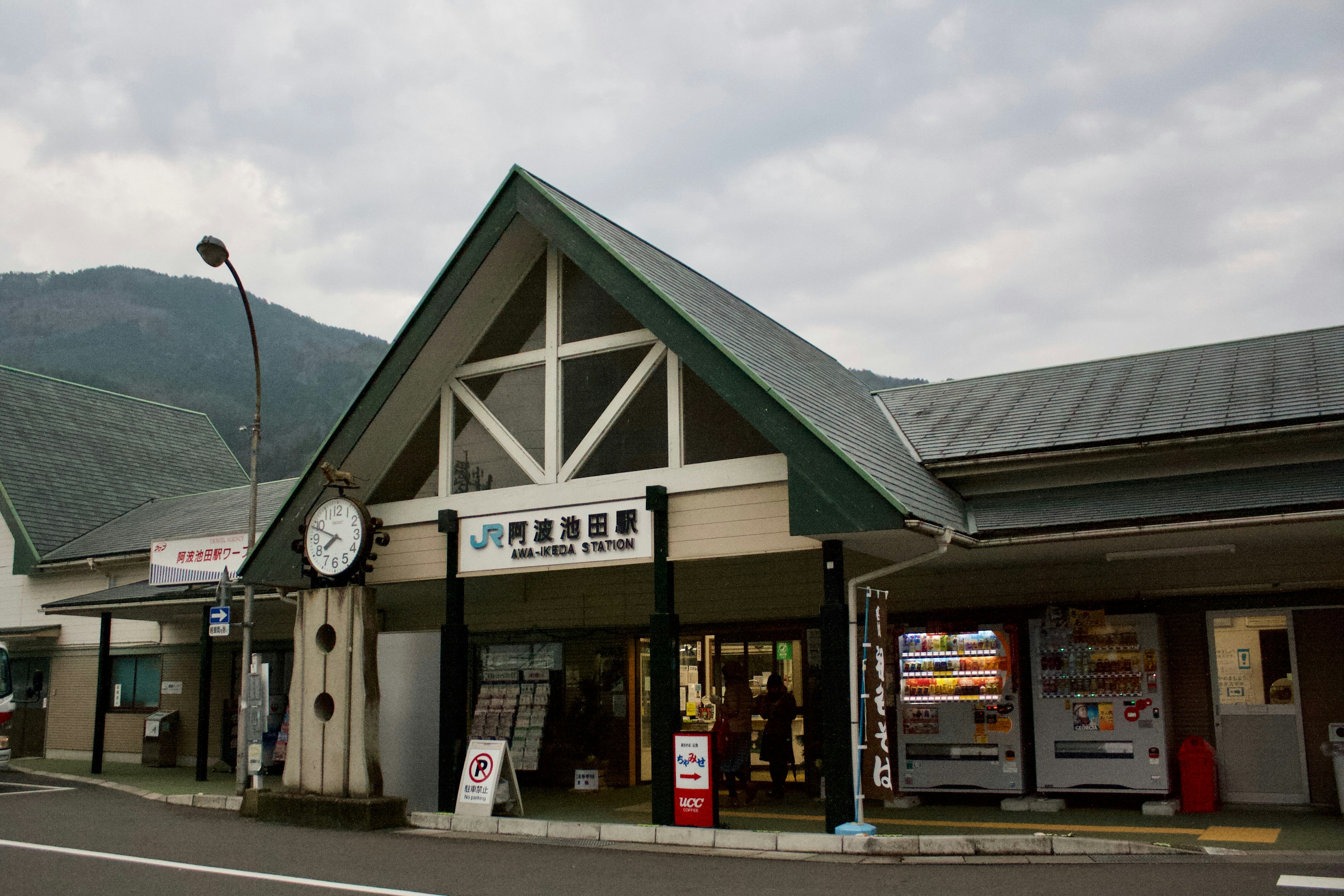 駅舎の外観に時計と緑の屋根がある