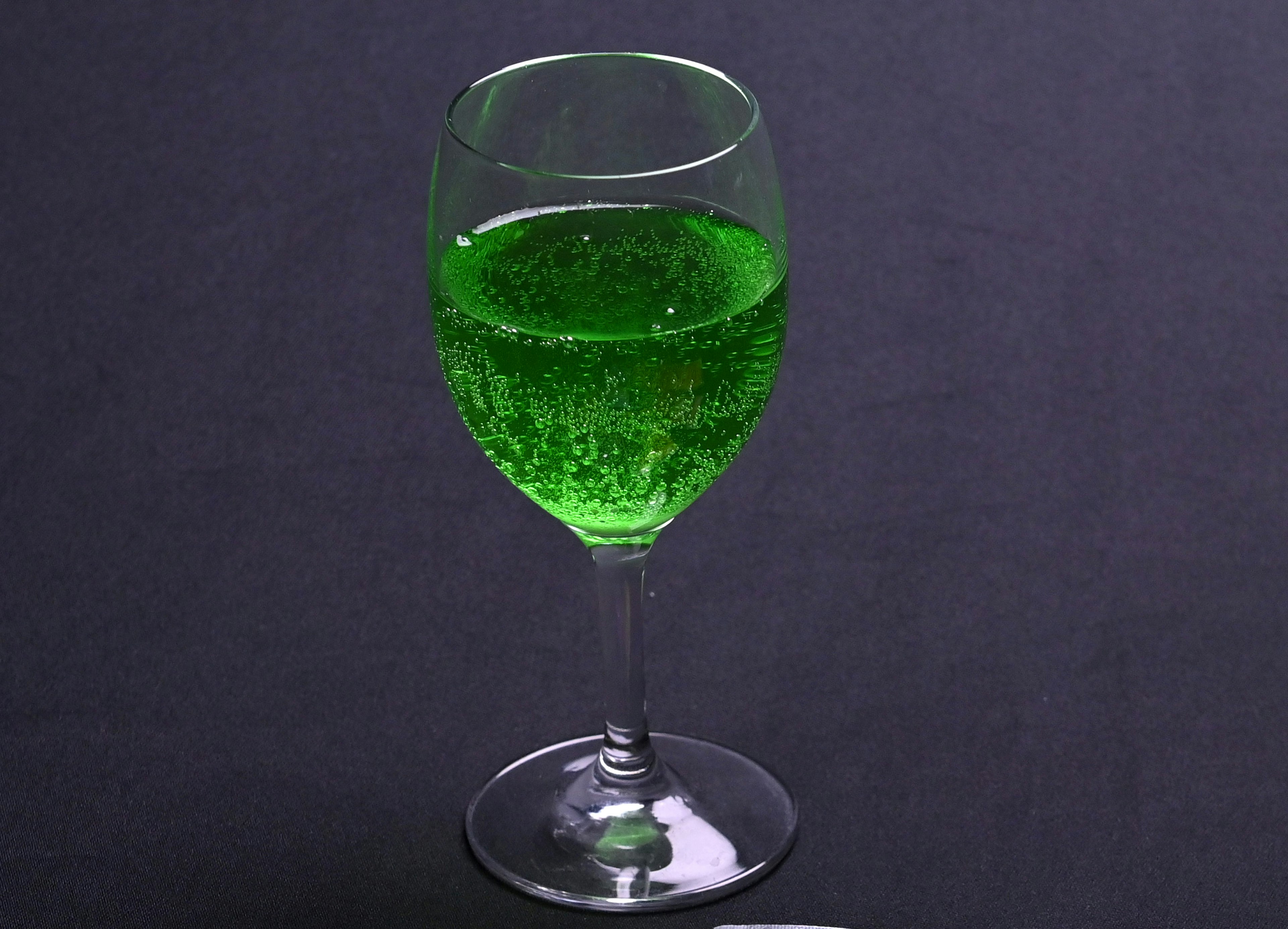 Verre en cristal rempli de boisson gazeuse verte