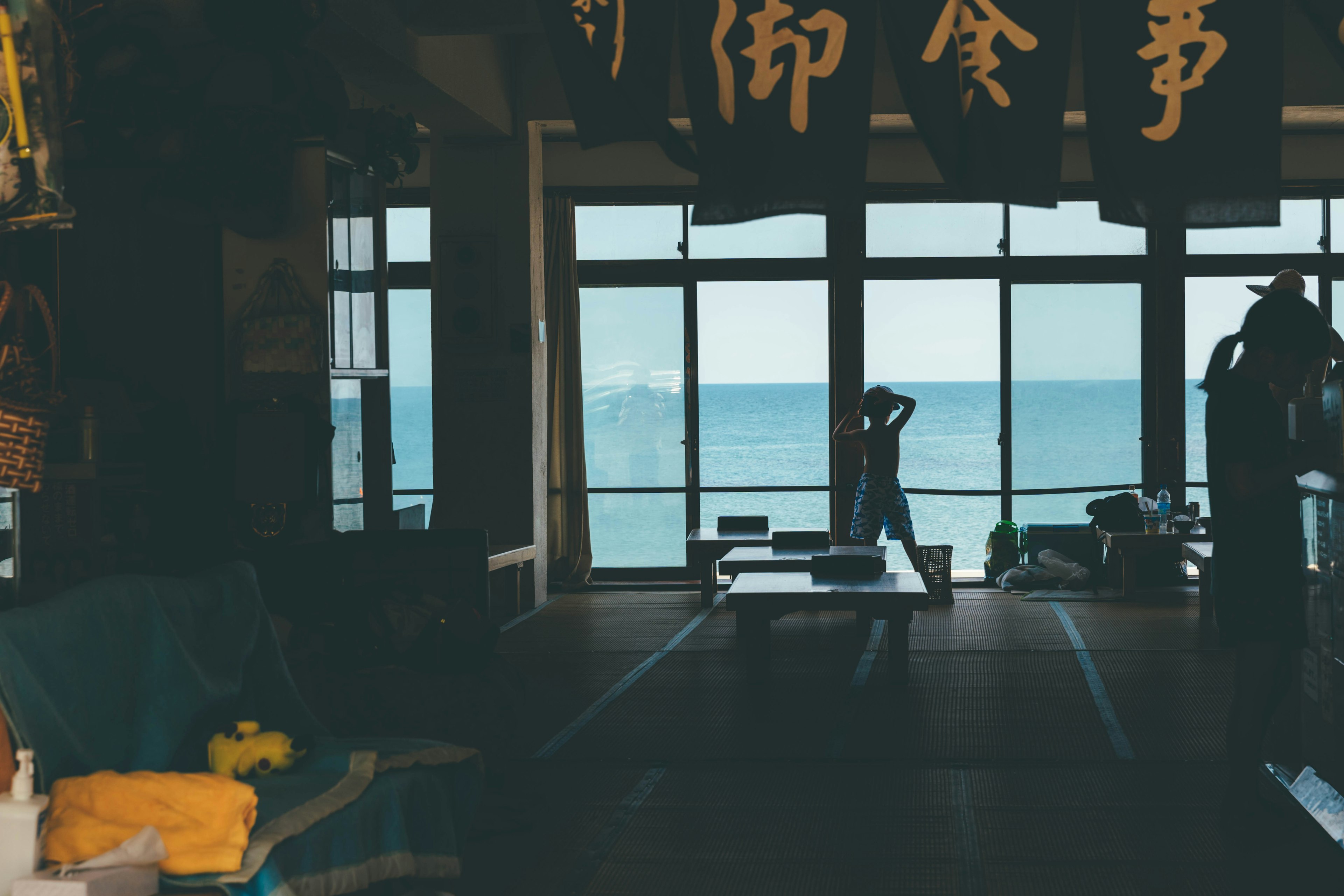 Indoor scene with windows overlooking the sea colorful fabrics and decorations visible