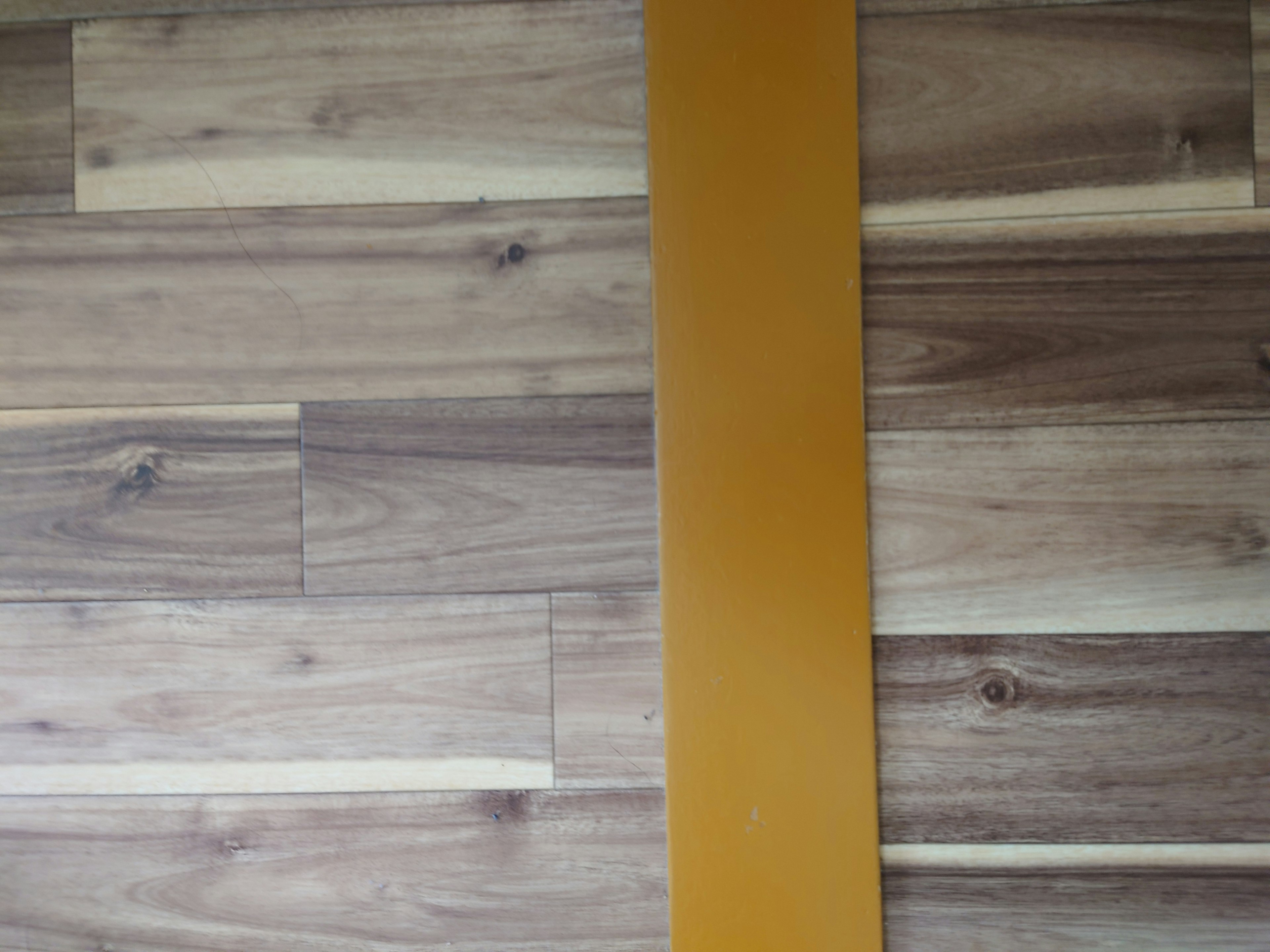 Orange rectangular object on wood grain floor