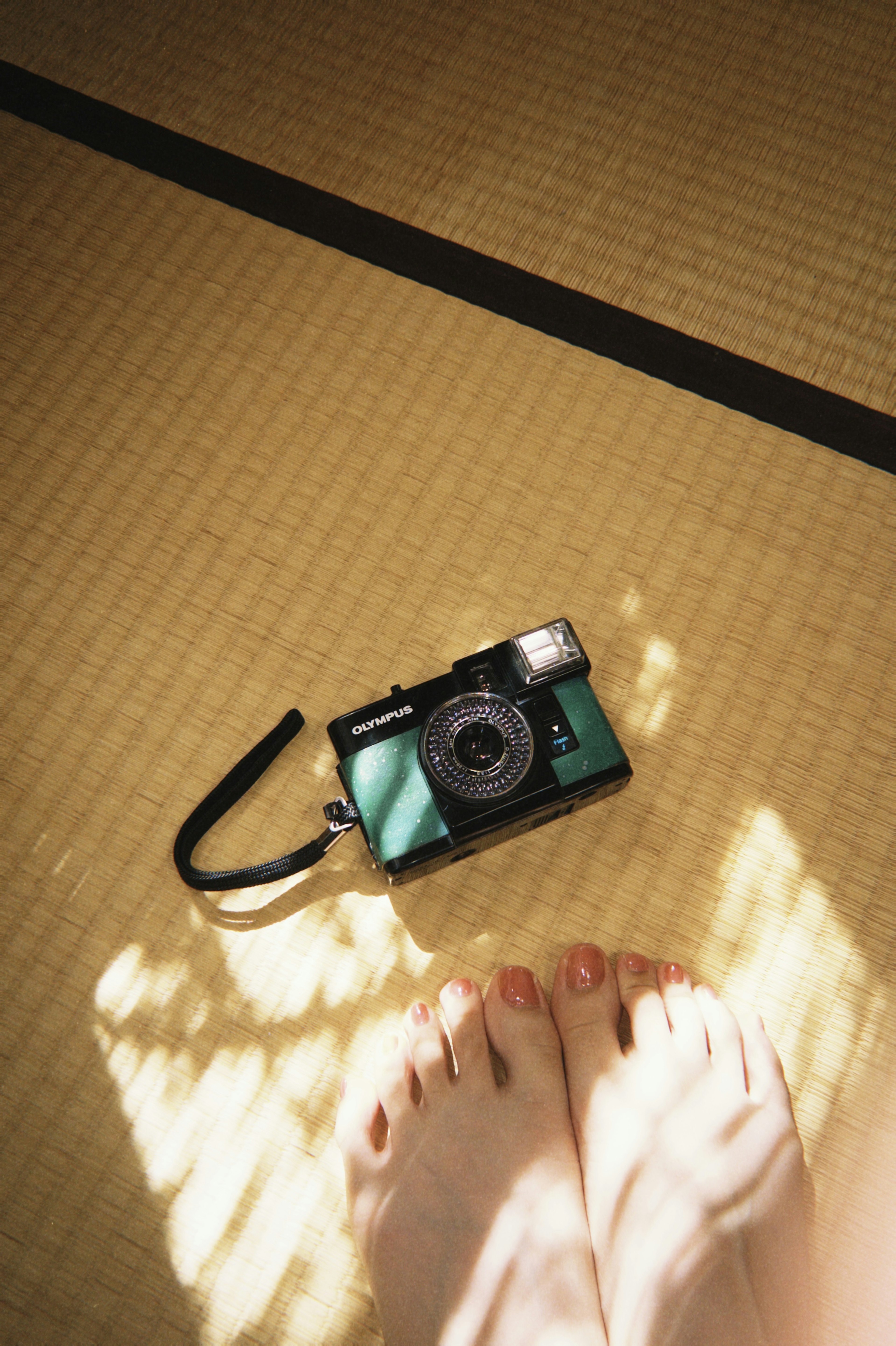 Foto di una macchina fotografica su pavimento tatami con piedi nudi