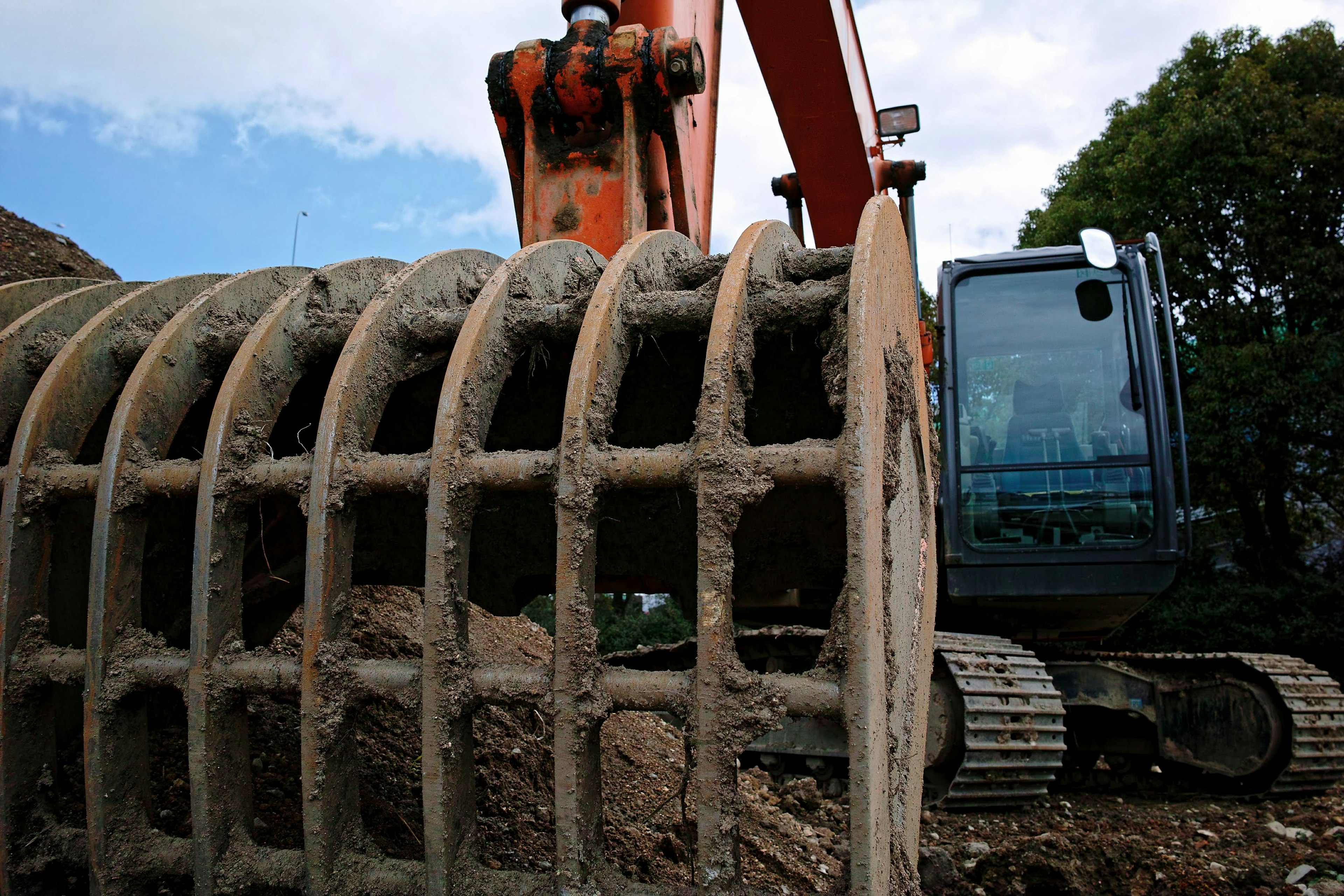 Chantier de construction avec un bras d'excavatrice et un cylindre en béton