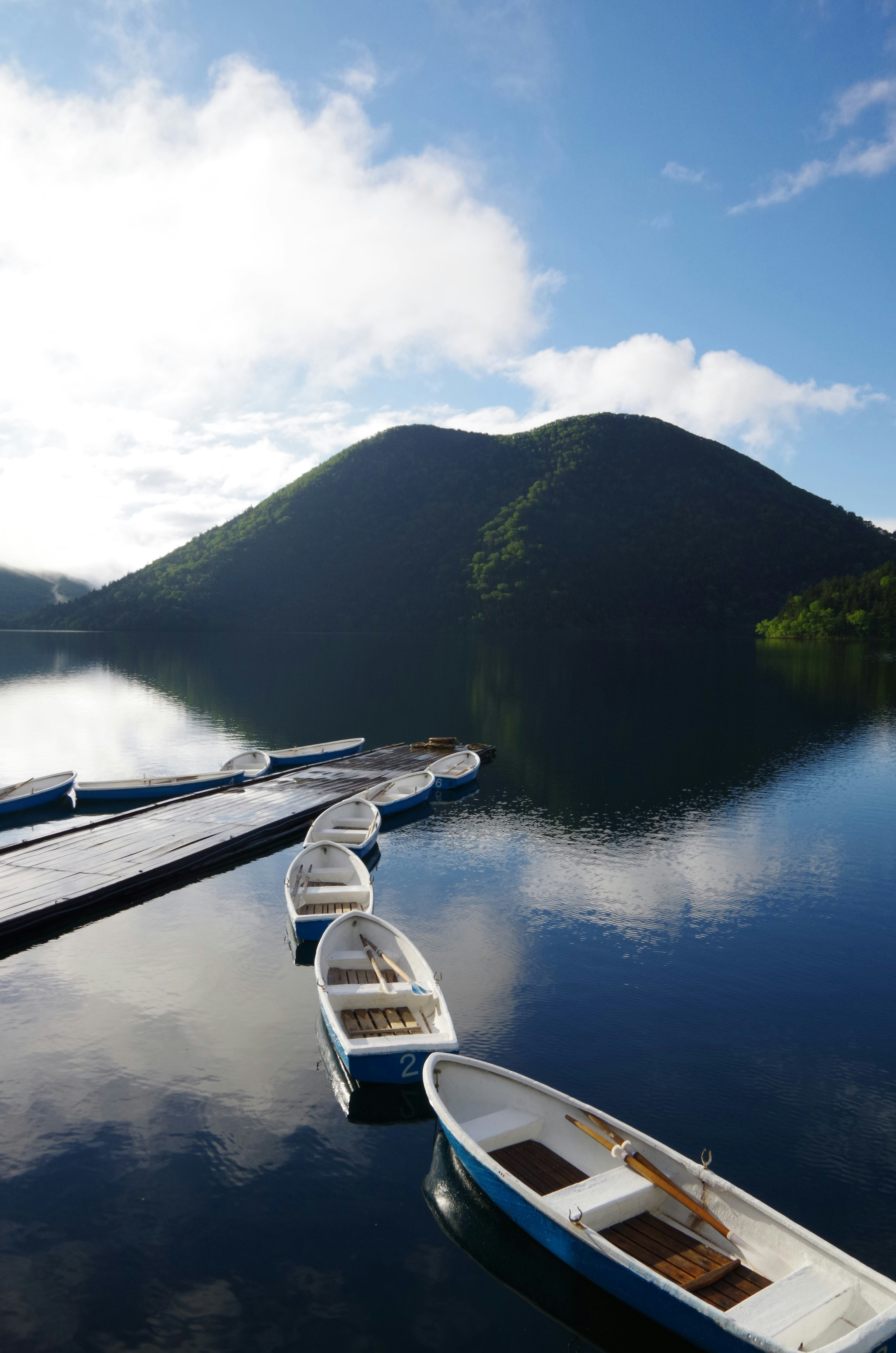 Lago sereno con pequeños botes y una hermosa vista de la montaña