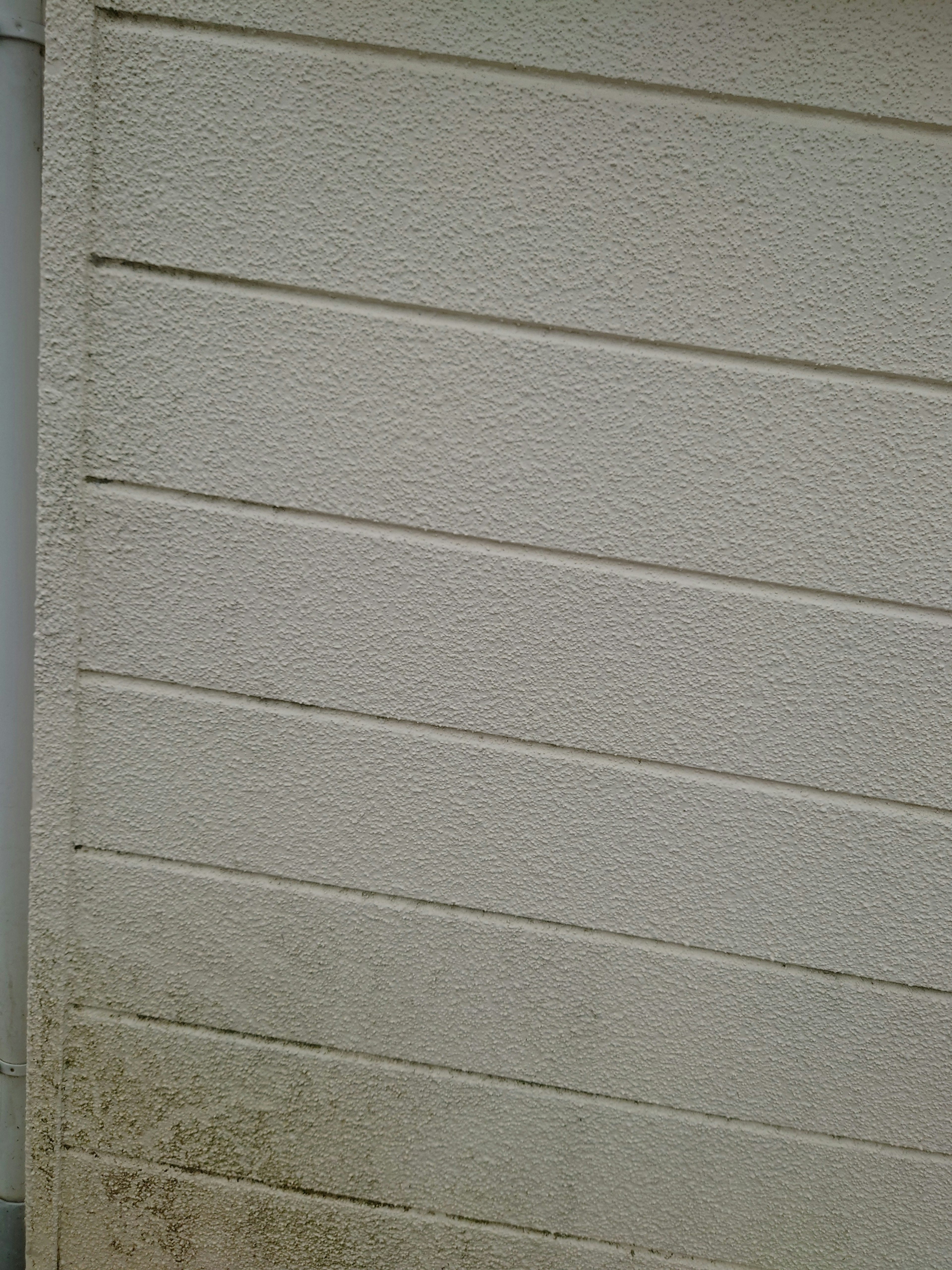 Textured surface of a dirty exterior wall with horizontal lines